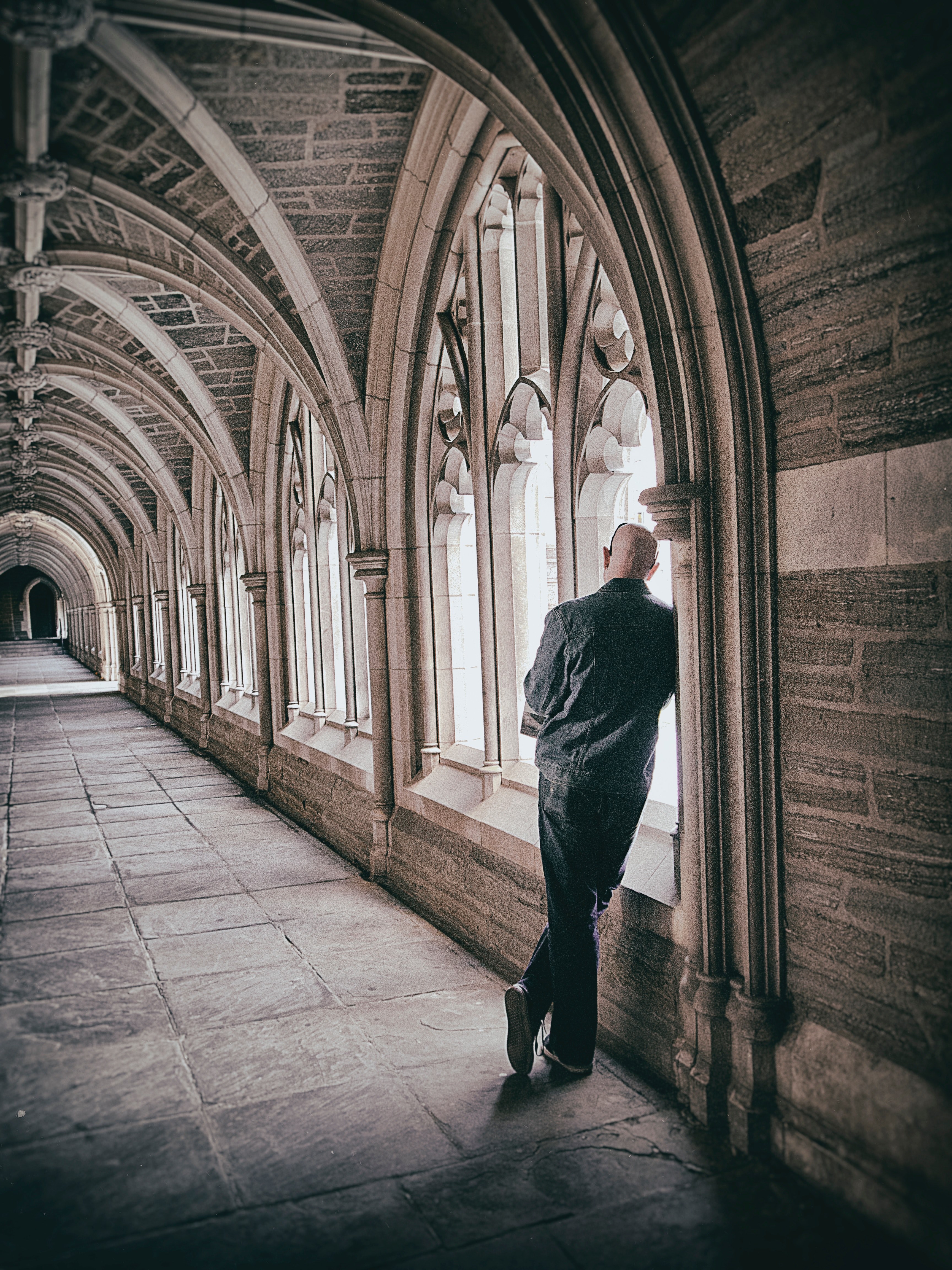 man leaning against wall in gothic medieval hallway architecture near windows with light coming through, medieval windows and man 4k, Phone HD Wallpaper