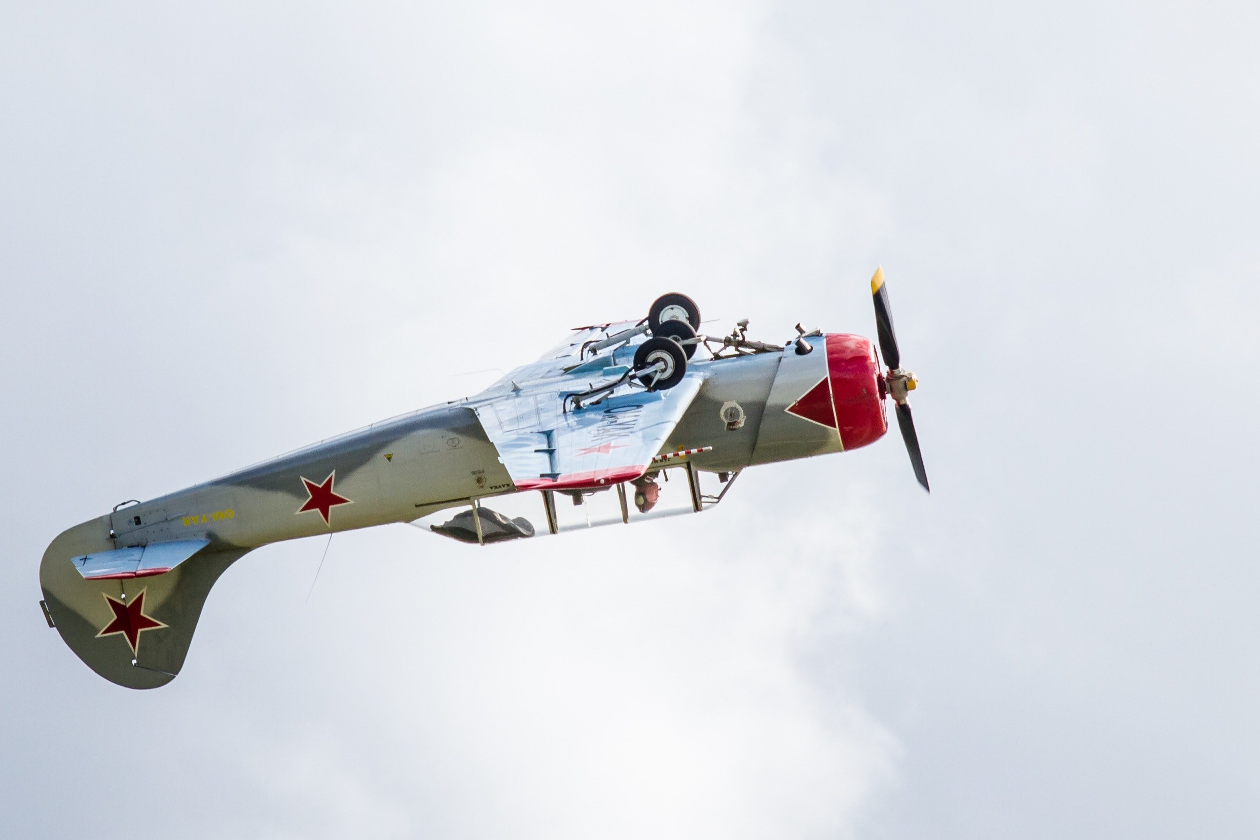 a vintage fighter jet plane flying upside down under a cloudy sky, aeroshow 4k, HD Wallpaper