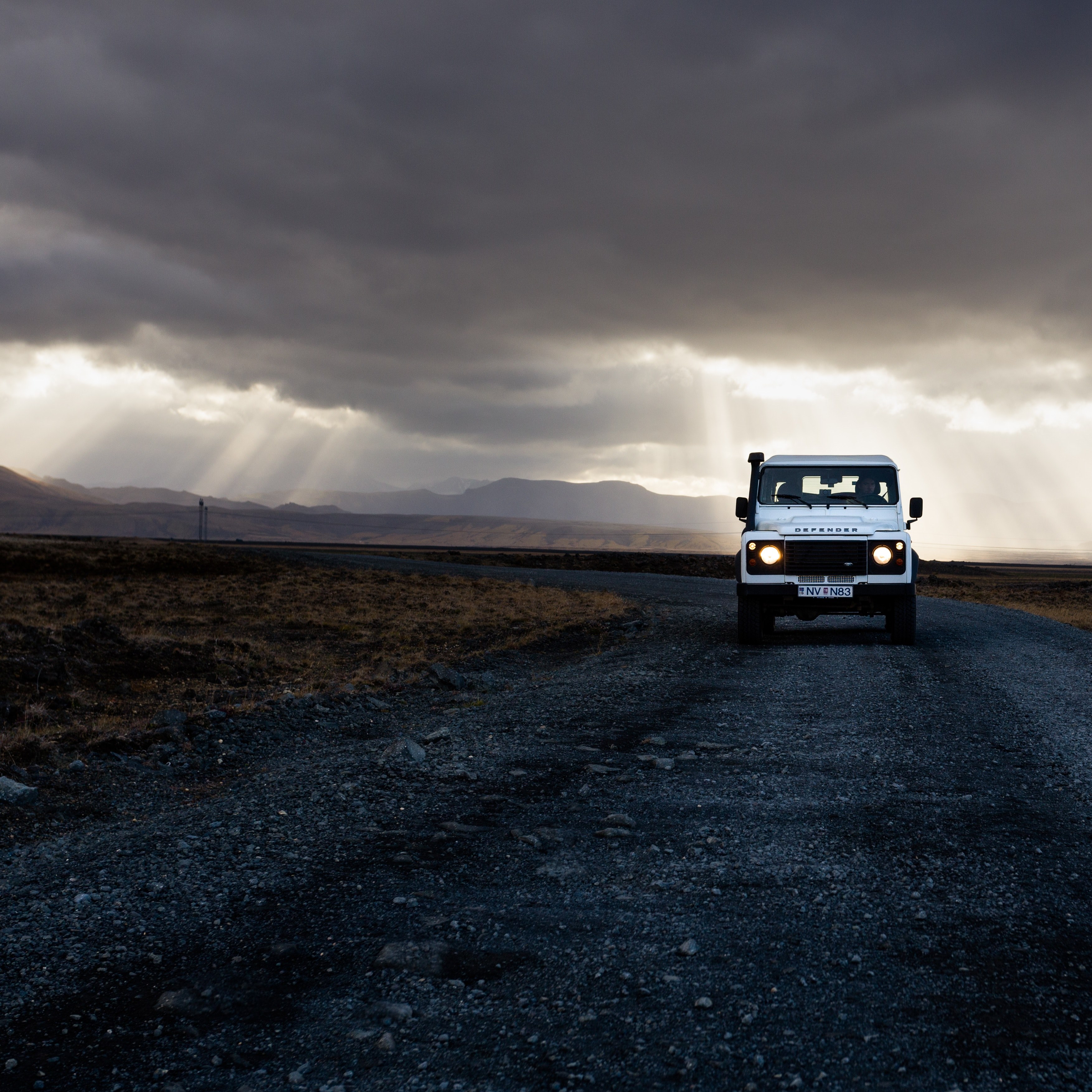 a white 4x4 truck driving down the road while rays of sun peek through the clouds in iceland, iceland drives 4k, HD Wallpaper