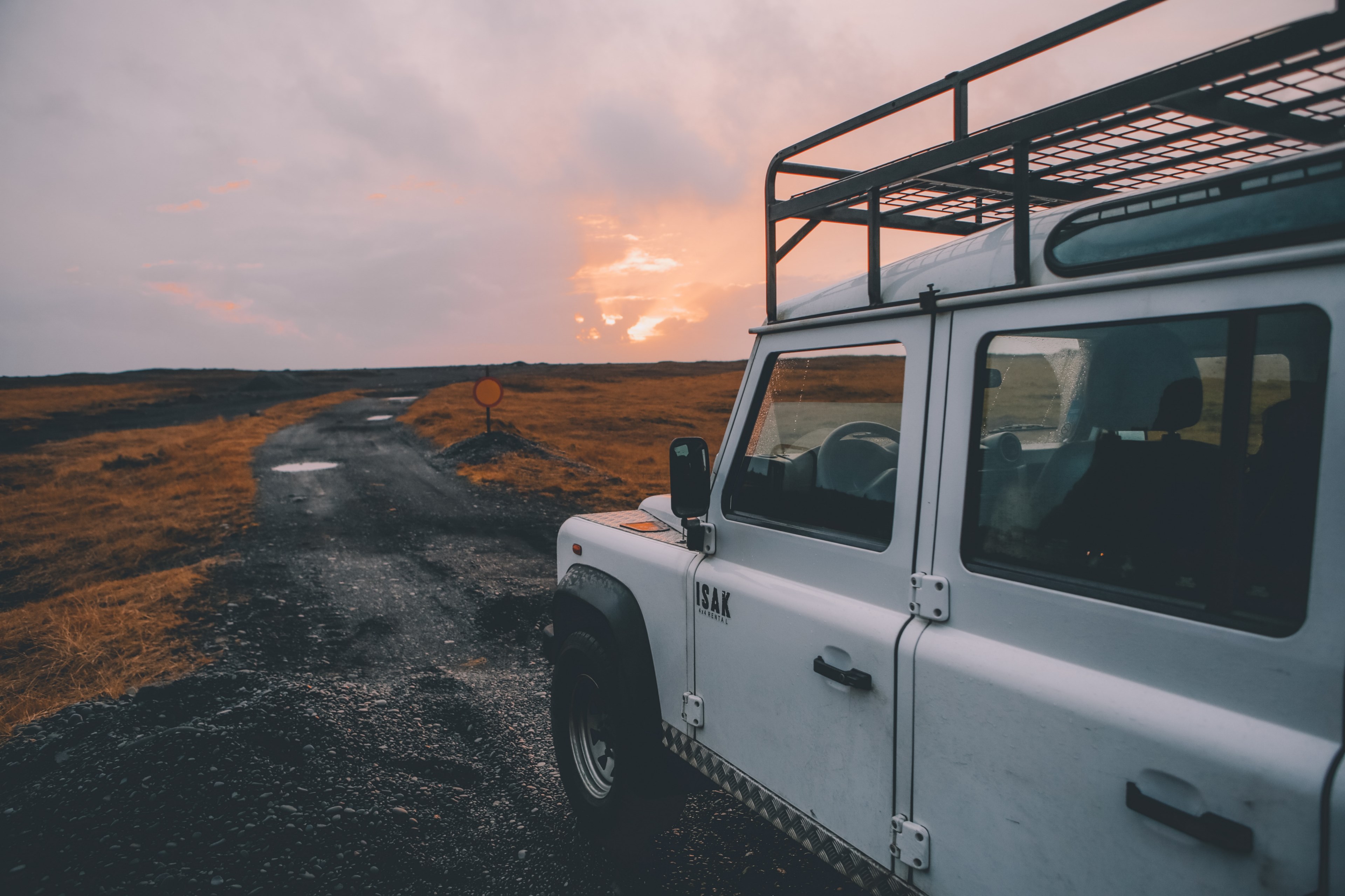 a side view of an off road vehicle driving on black dirt in an empty plain, white suv on black dirt 4k, HD Wallpaper