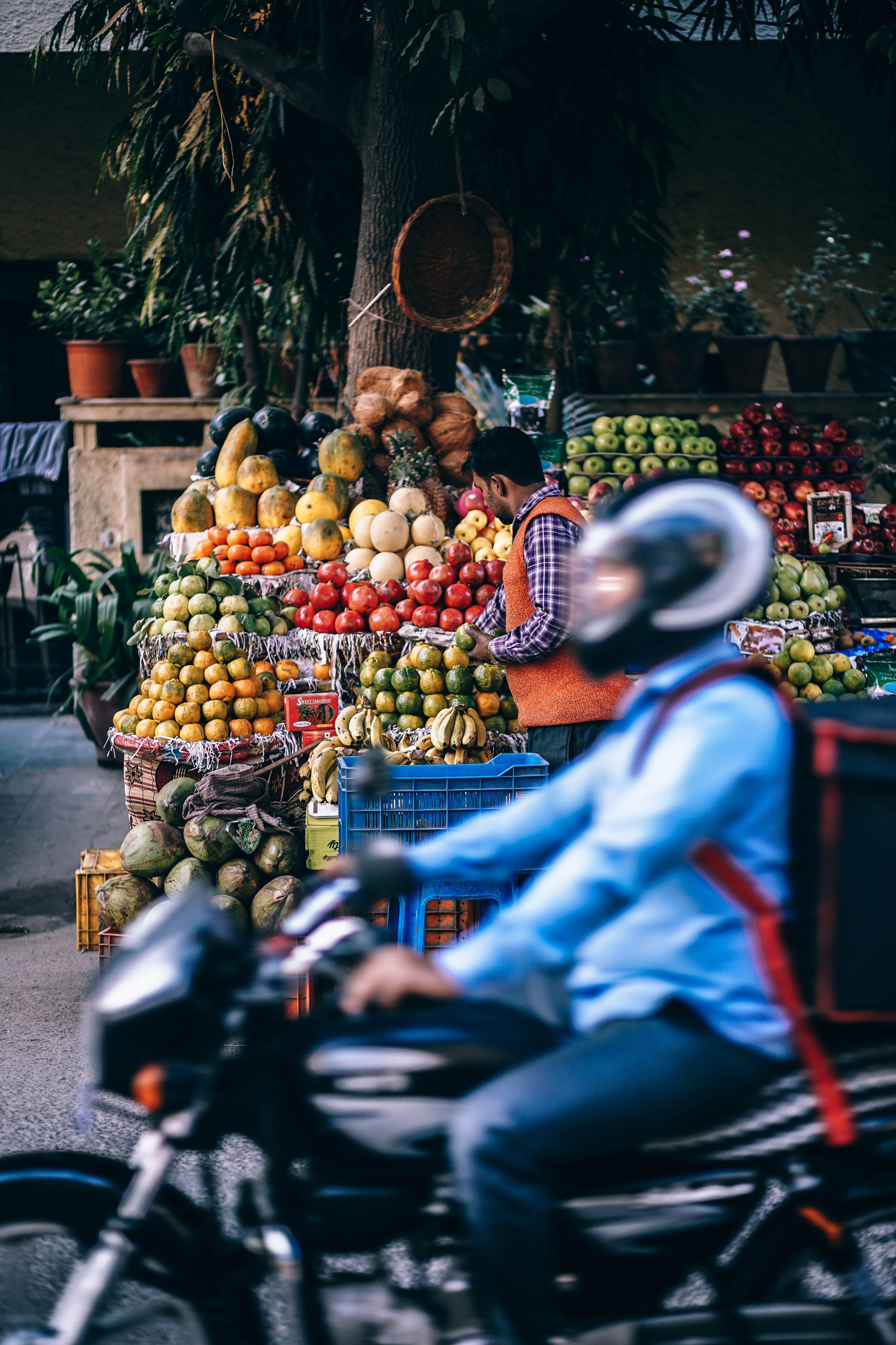 motorcyclist rides past a street vendor stand with fresh fruits and vegetables, fruit stall 4k, Phone HD Wallpaper