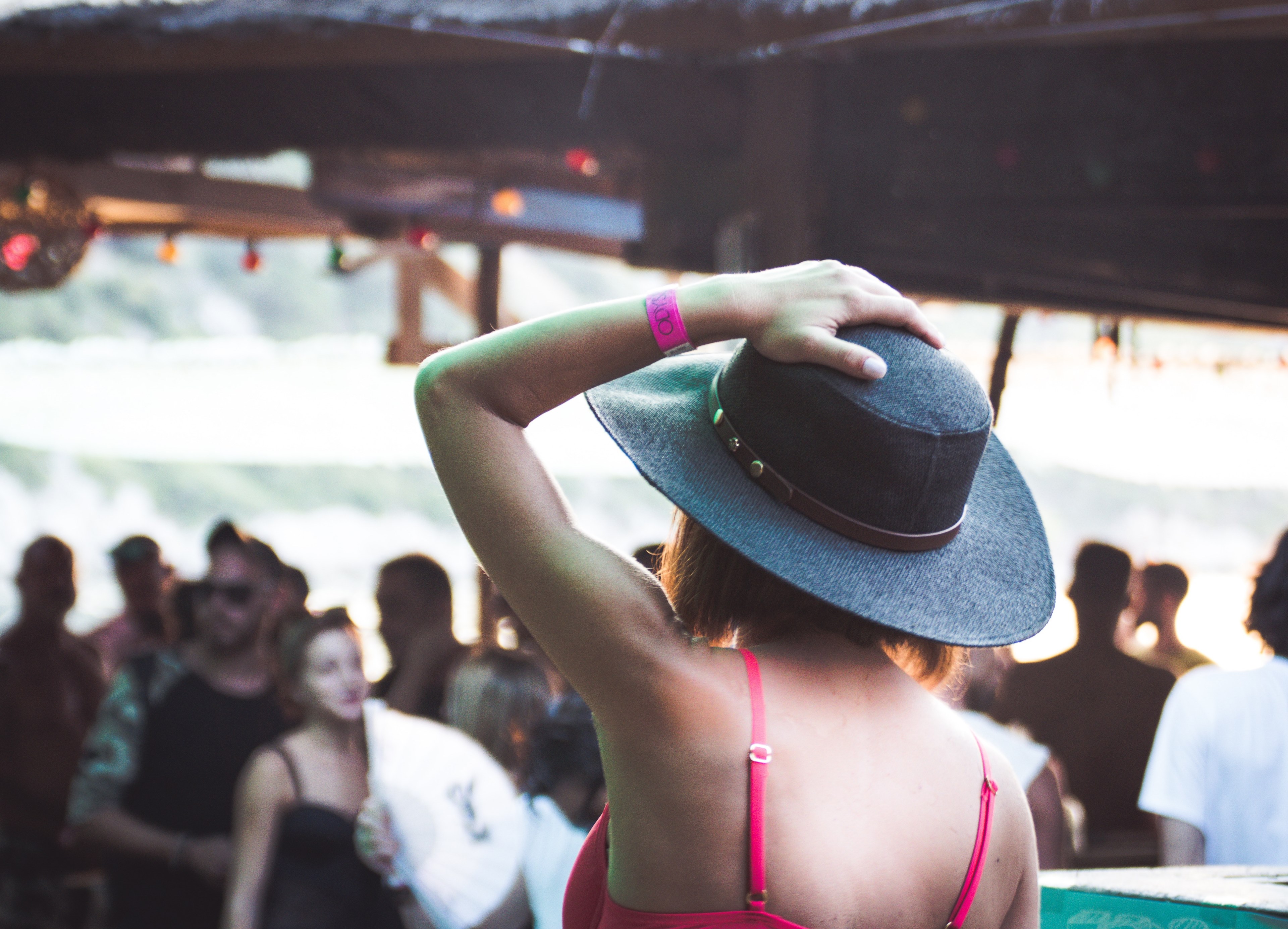 a woman is holding her hat and facing the crowd at cariocas beach bar, woman hat cariocas beach bar 4k, HD Wallpaper