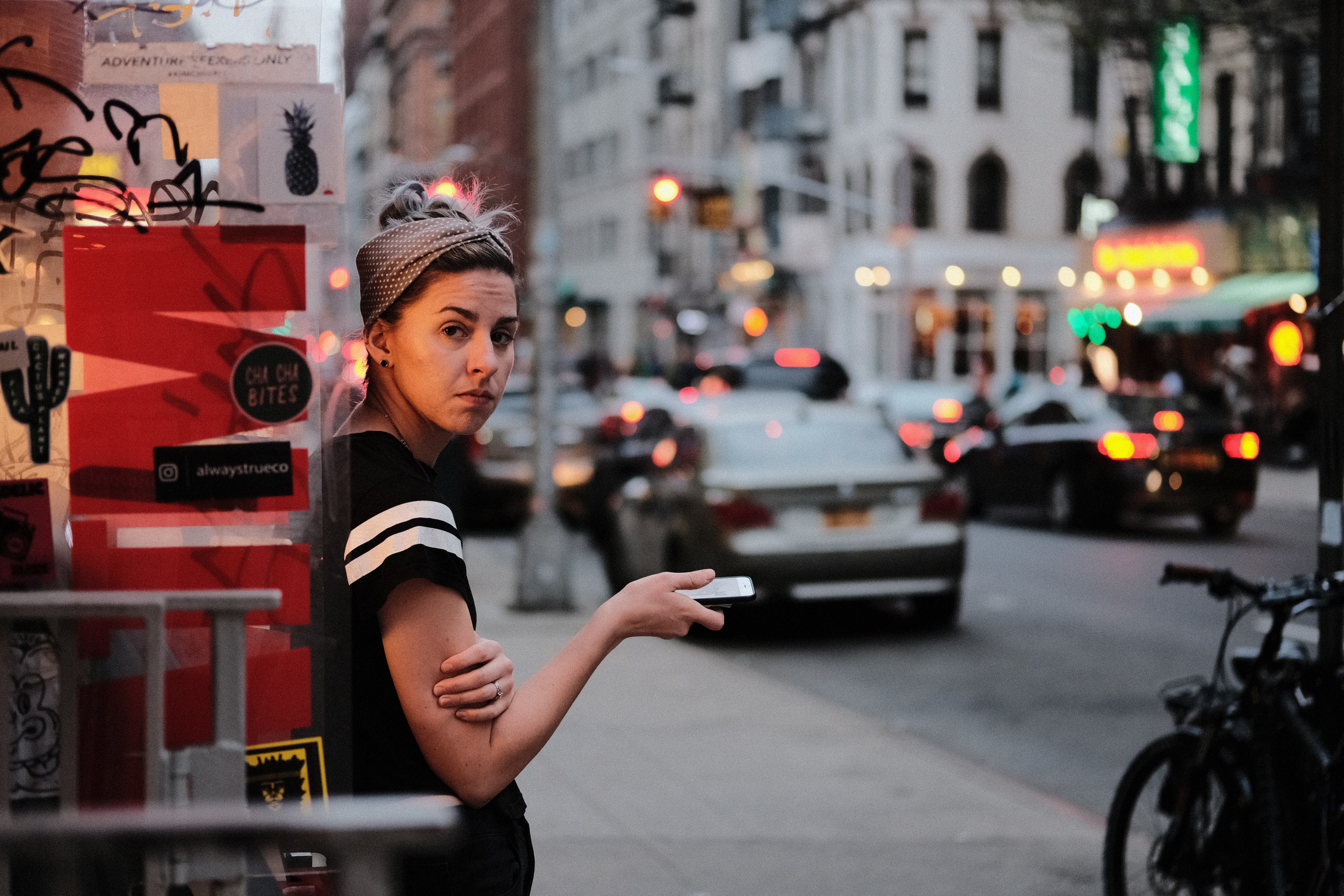 a woman in a headwrap looks down at her phone on the lower east side, long shift 4k, HD Wallpaper