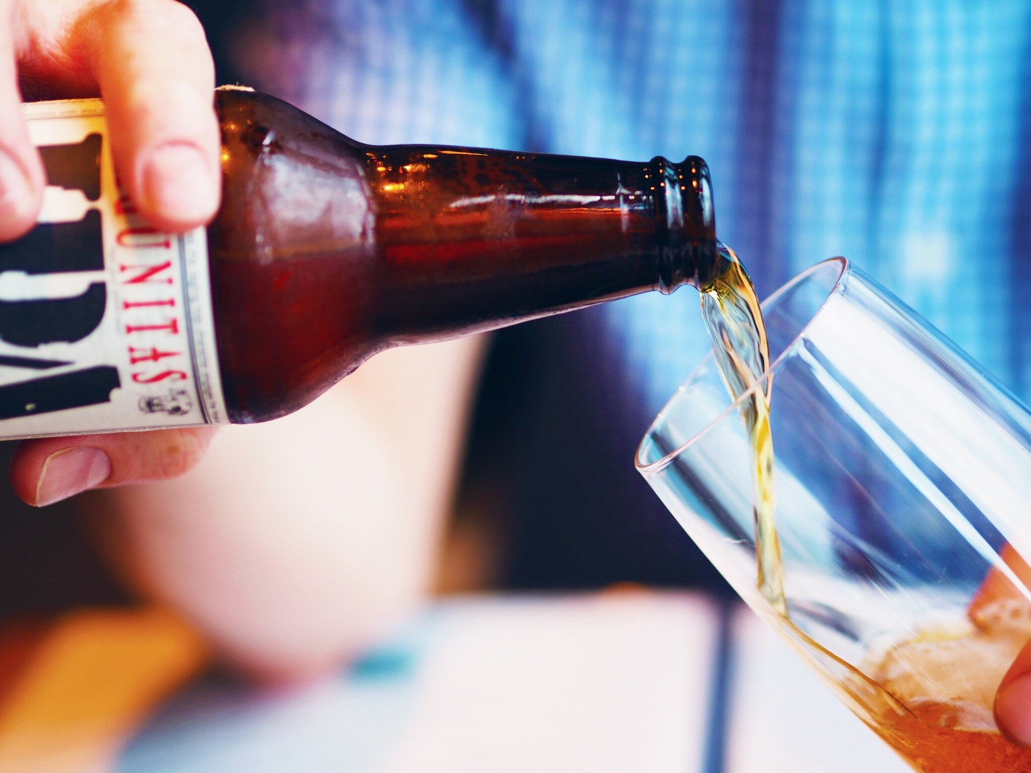 a person in a blue shirt pouring beer into a tall glass, after work drink 4k, HD Wallpaper