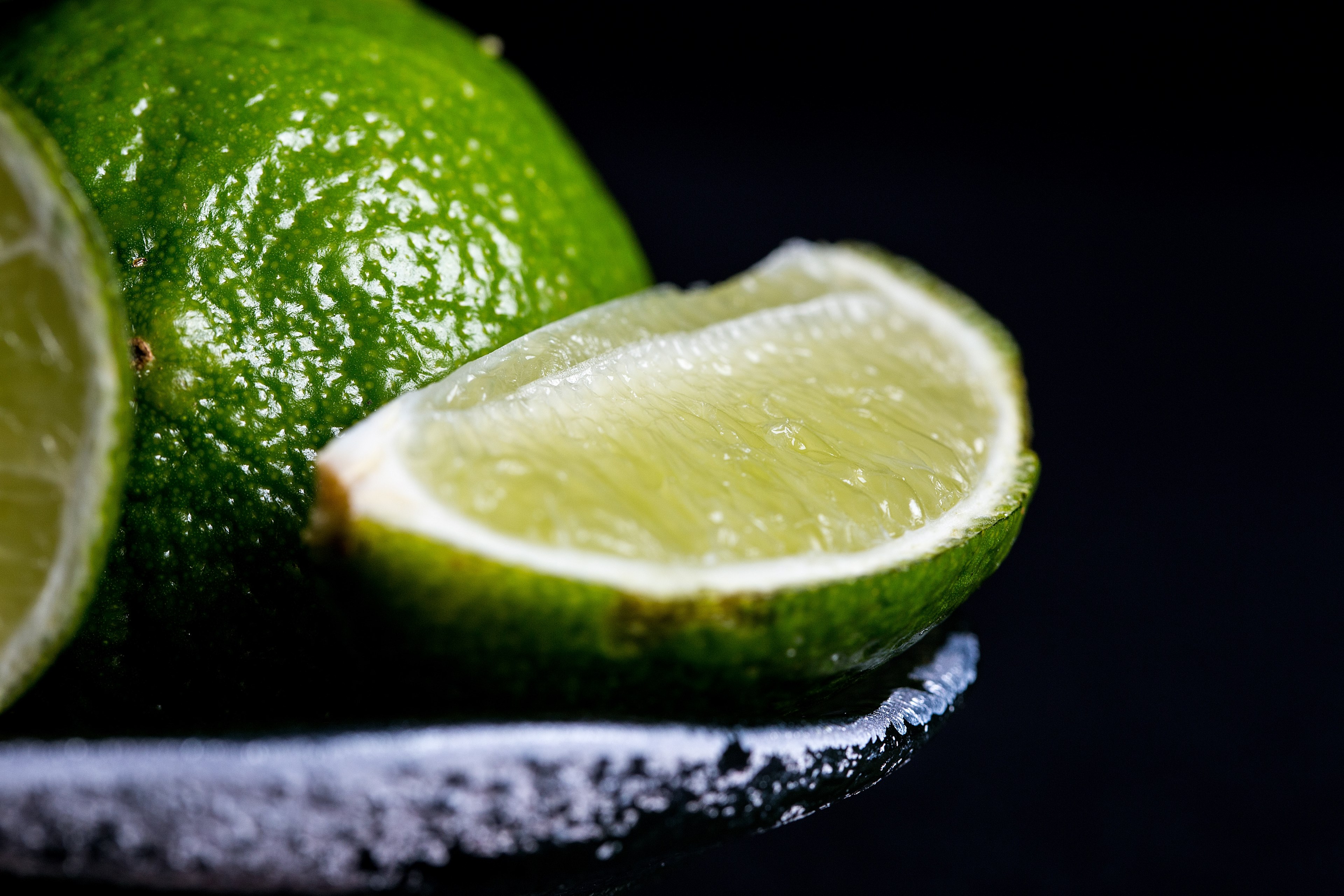 slices of fresh lime in a bowl on a black backdrop, cut citrus fruit 4k, HD Wallpaper