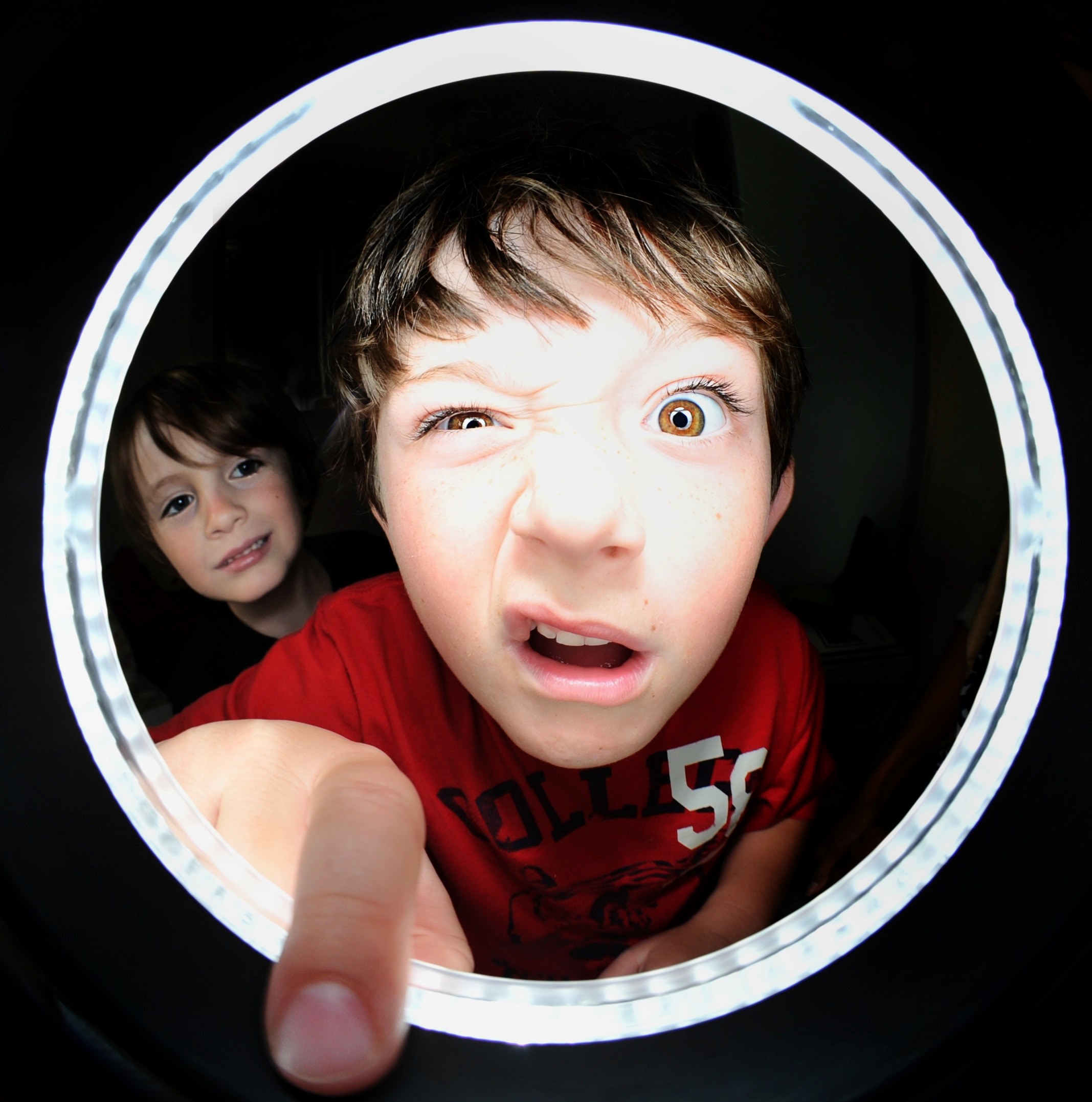 a little boy making a funny face while sticking his finger through a peephole, _boy looking peephole 4k, Phone HD Wallpaper