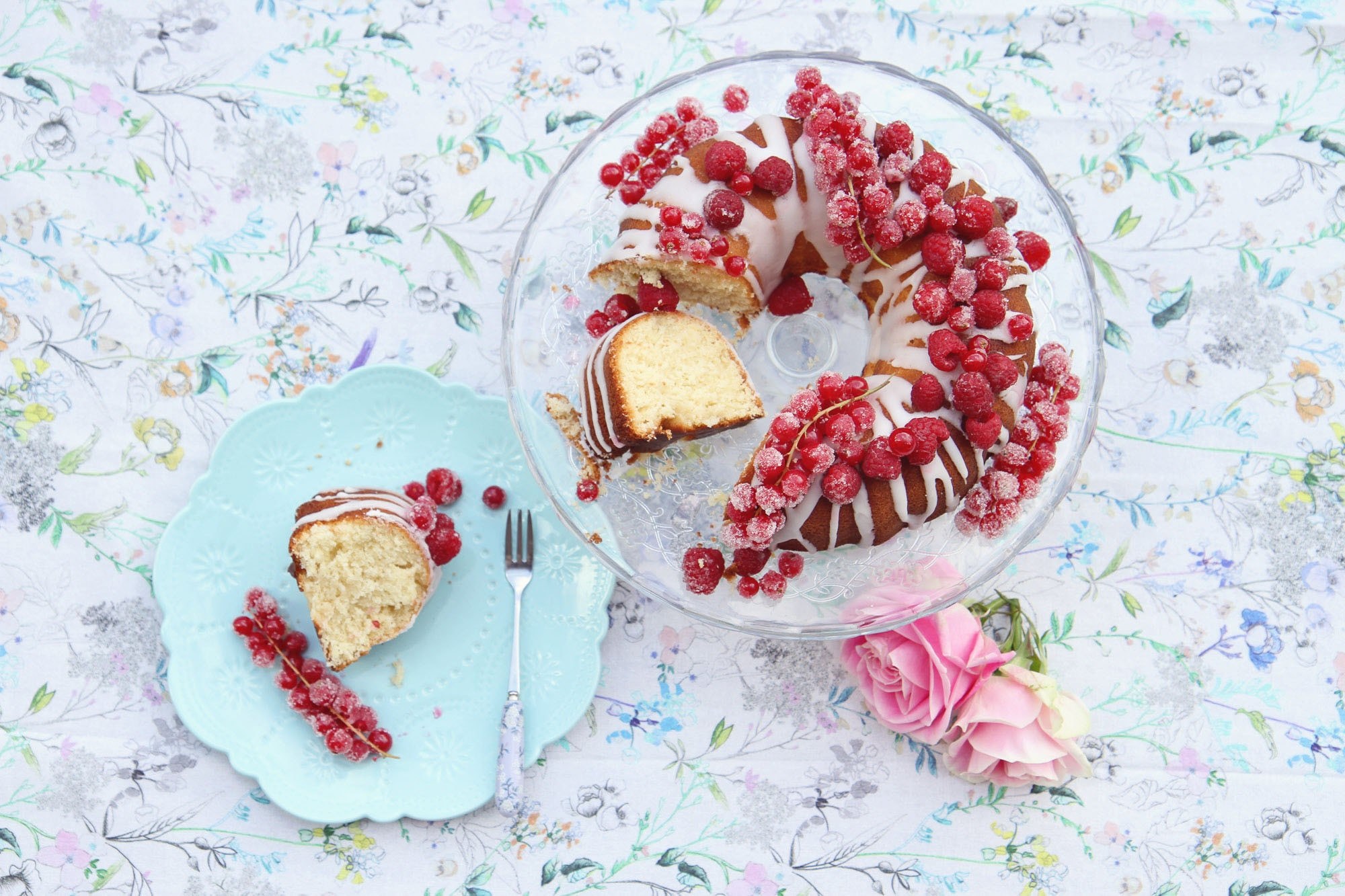 a bundt cake covered in white frosting cut up on a crystal platter with pieces on plates around it in bristol, slick of dessert 4k, HD Wallpaper