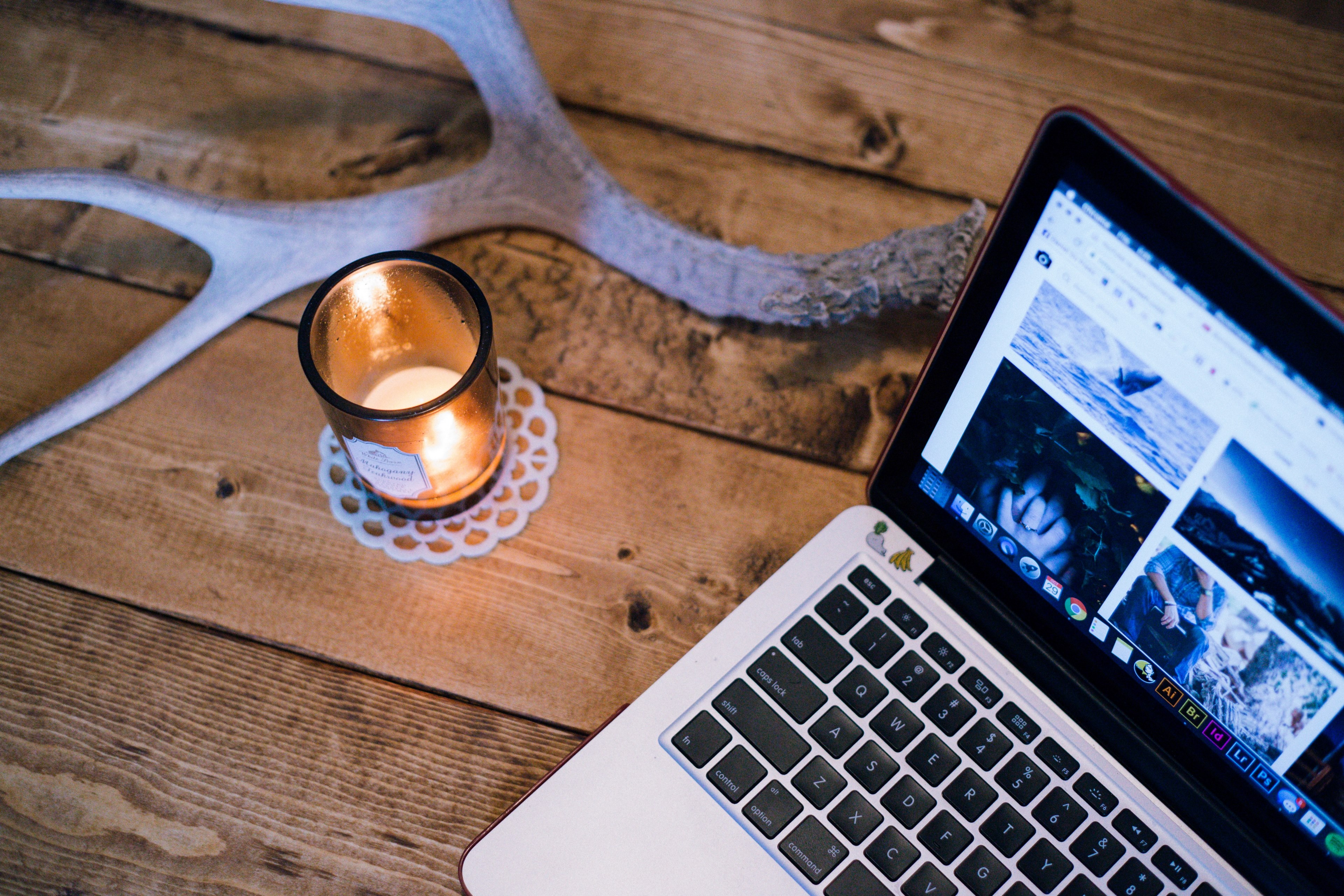 a lit candle and an antler on a table next to a laptop, candle antler and laptop 4k, HD Wallpaper