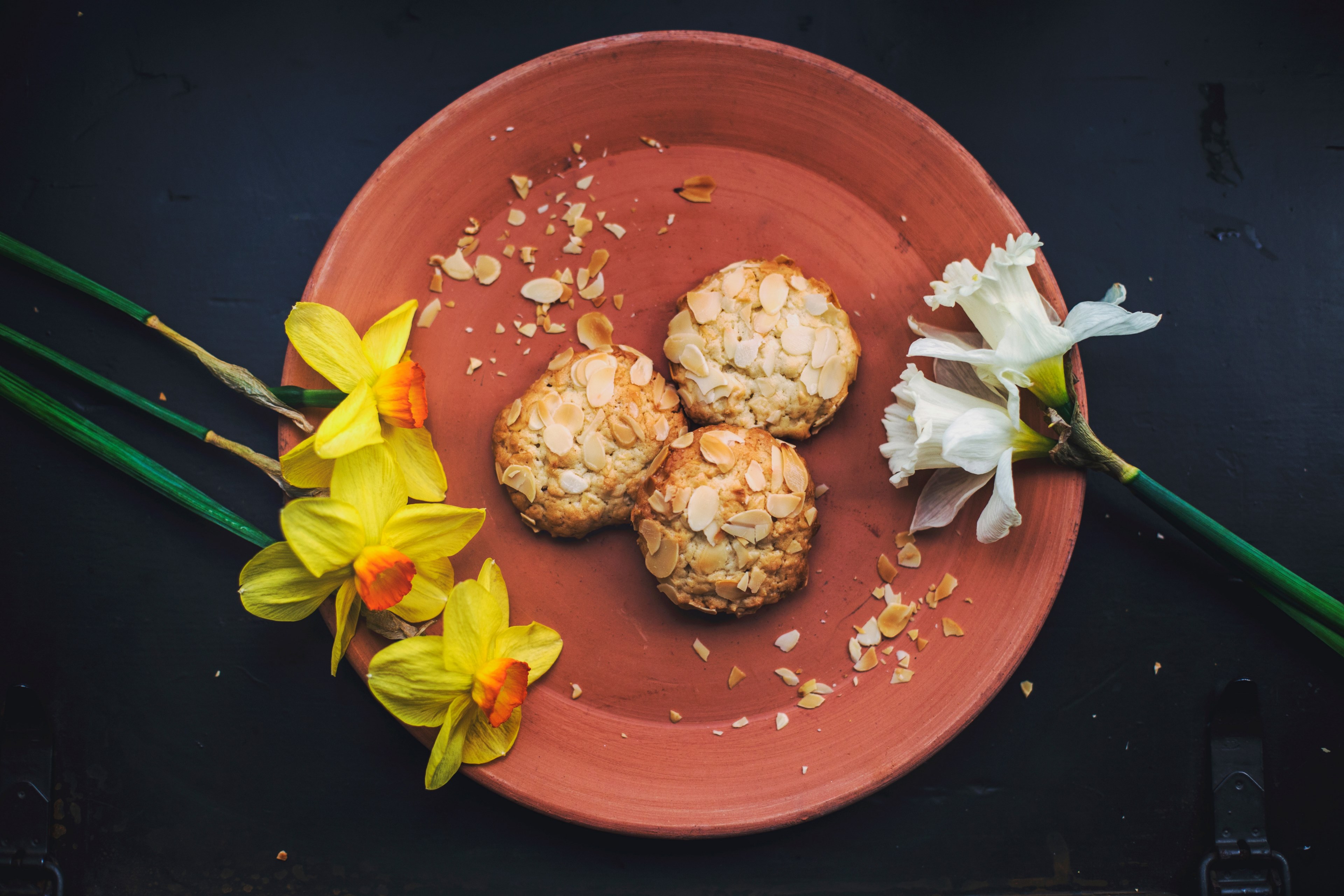 overhead shot of fresh almond cookies plated with daffodils, cookies and flowers 4k, HD Wallpaper