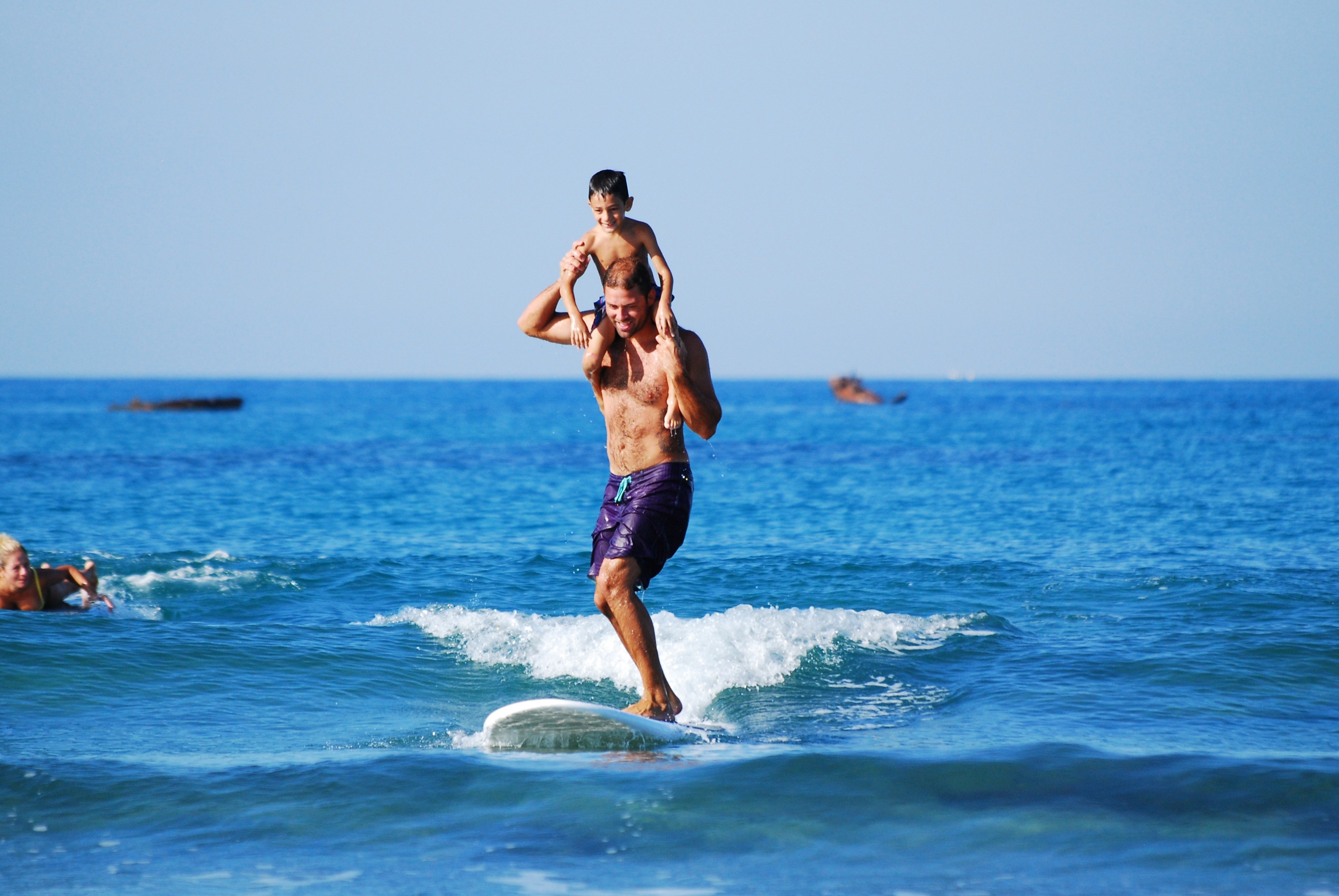boy on his fathers shoulders who is surfing on a board, smiling with a big smile 4k, HD Wallpaper