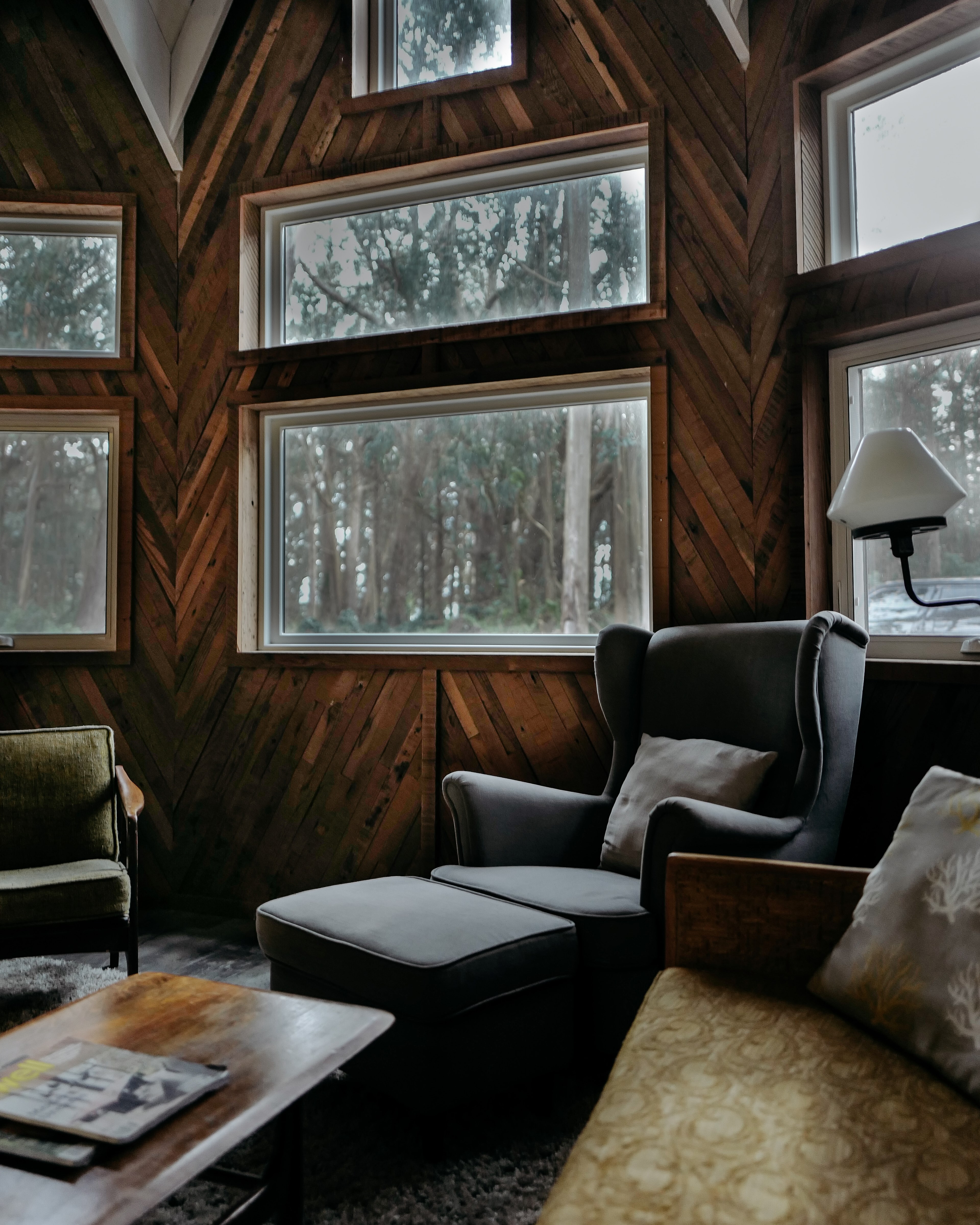 black ottoman leans against rustic styled windows nestled in a forest, retreat at the oyster suite 4k, Phone HD Wallpaper