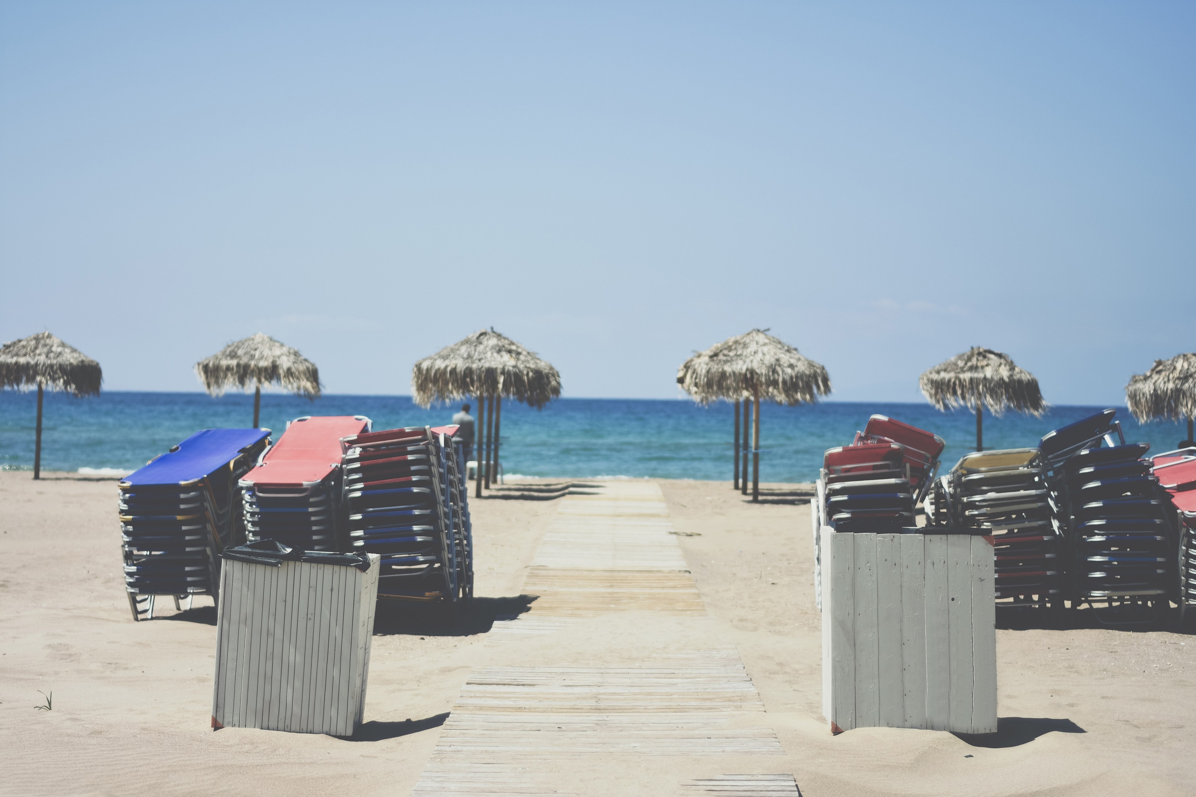 stacked deck chairs and straw umbrellas on an empty beach, beach at the end of a day 4k, HD Wallpaper