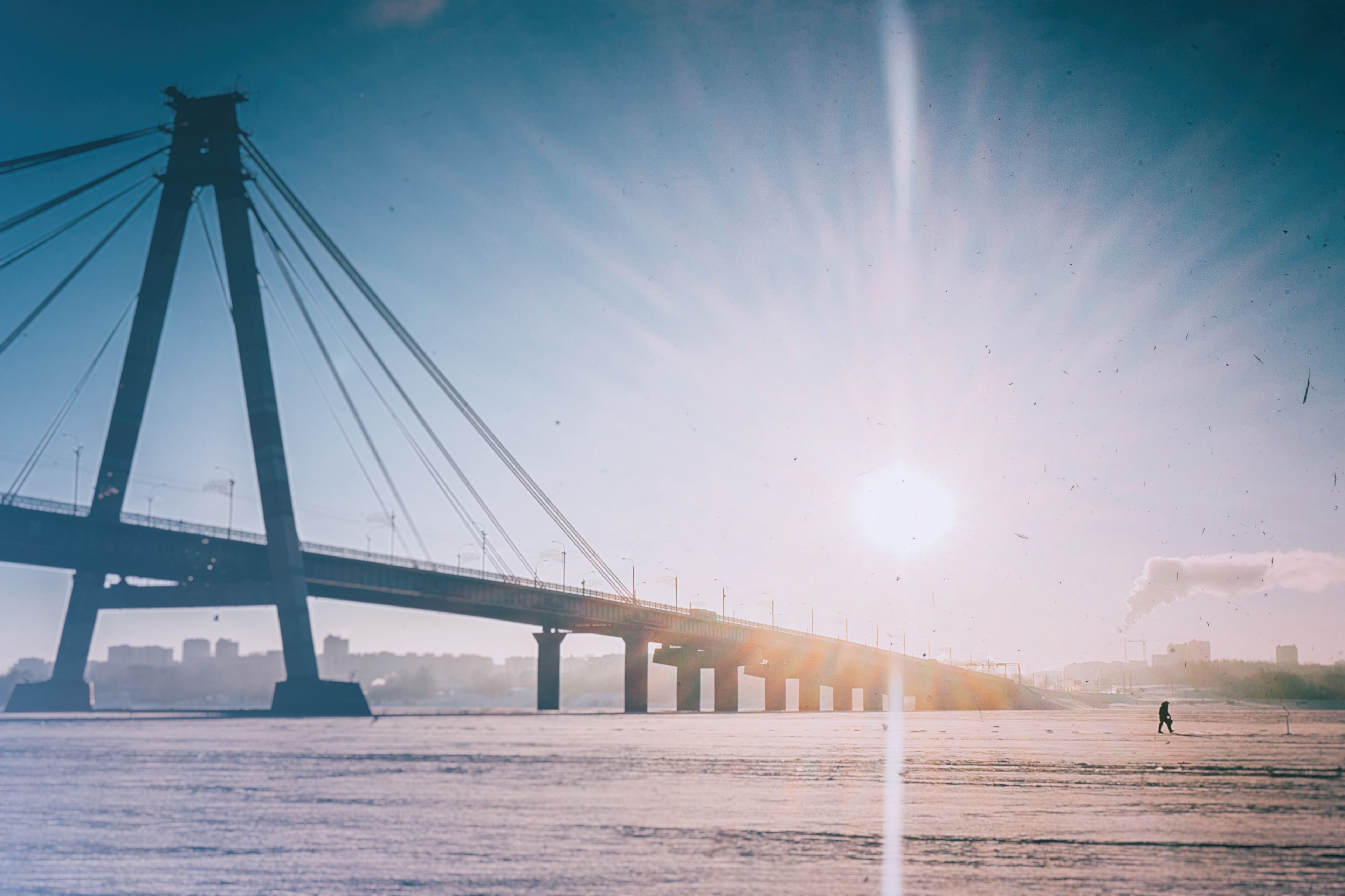 a by the sun illuminated bridge in cherepovets spans over ice during winter a winter day, sunny bridge in the winter 4k, HD Wallpaper