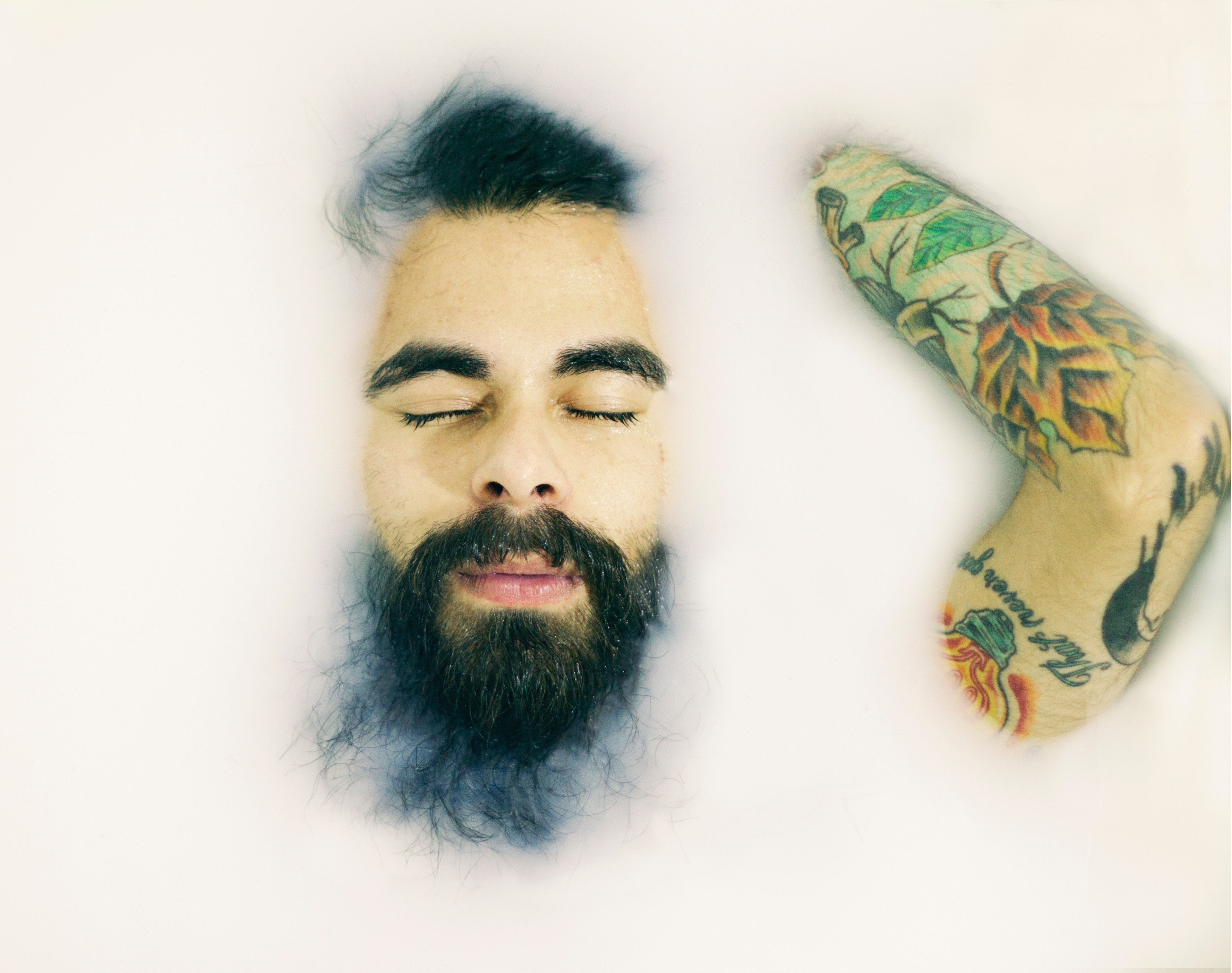 man with a beard and arm tattoo laying with eyes closed in a milk bath, milk bath 4k, HD Wallpaper