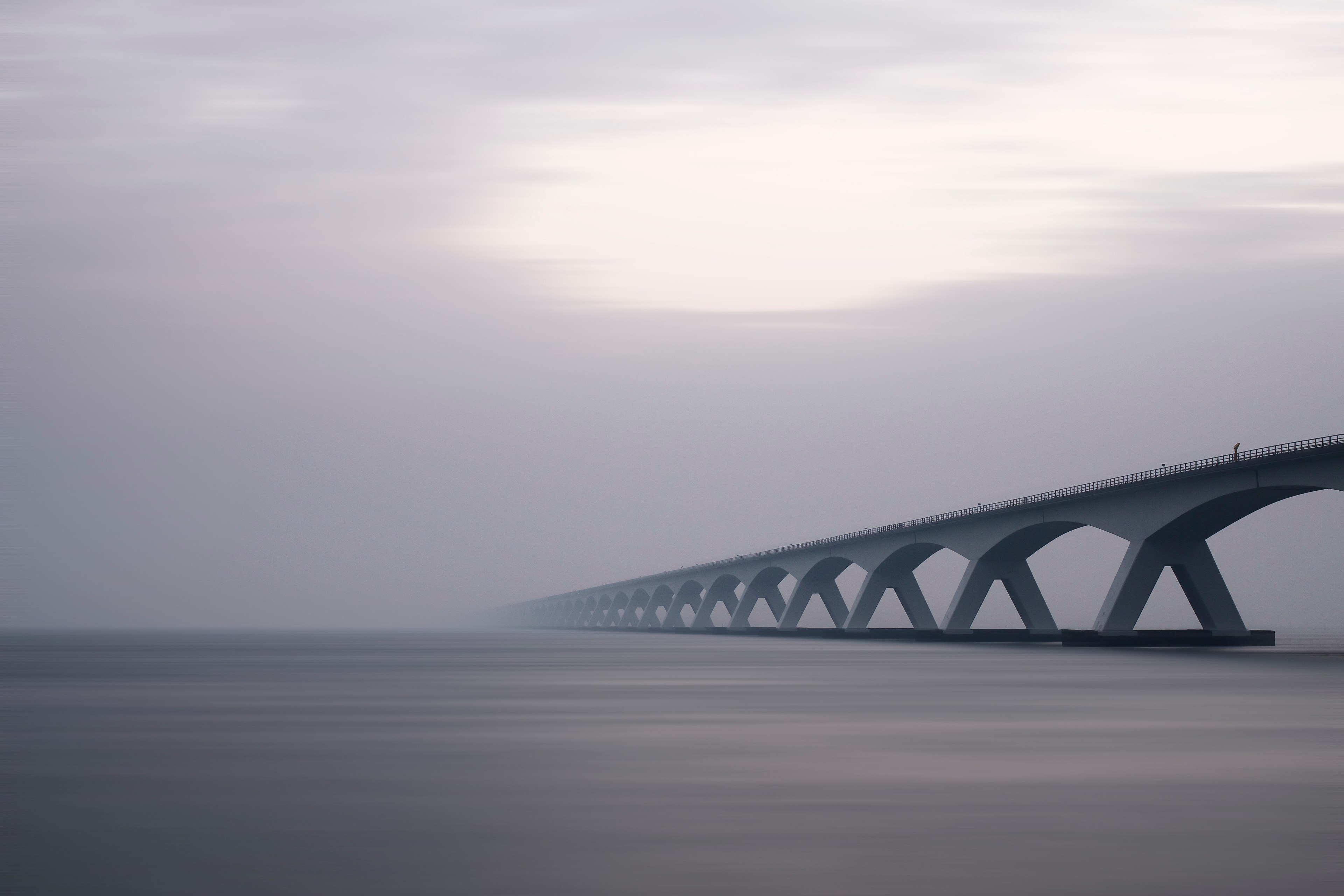 a gray day by a bridge over calm foggy waters, overcast city structures 4k, HD Wallpaper