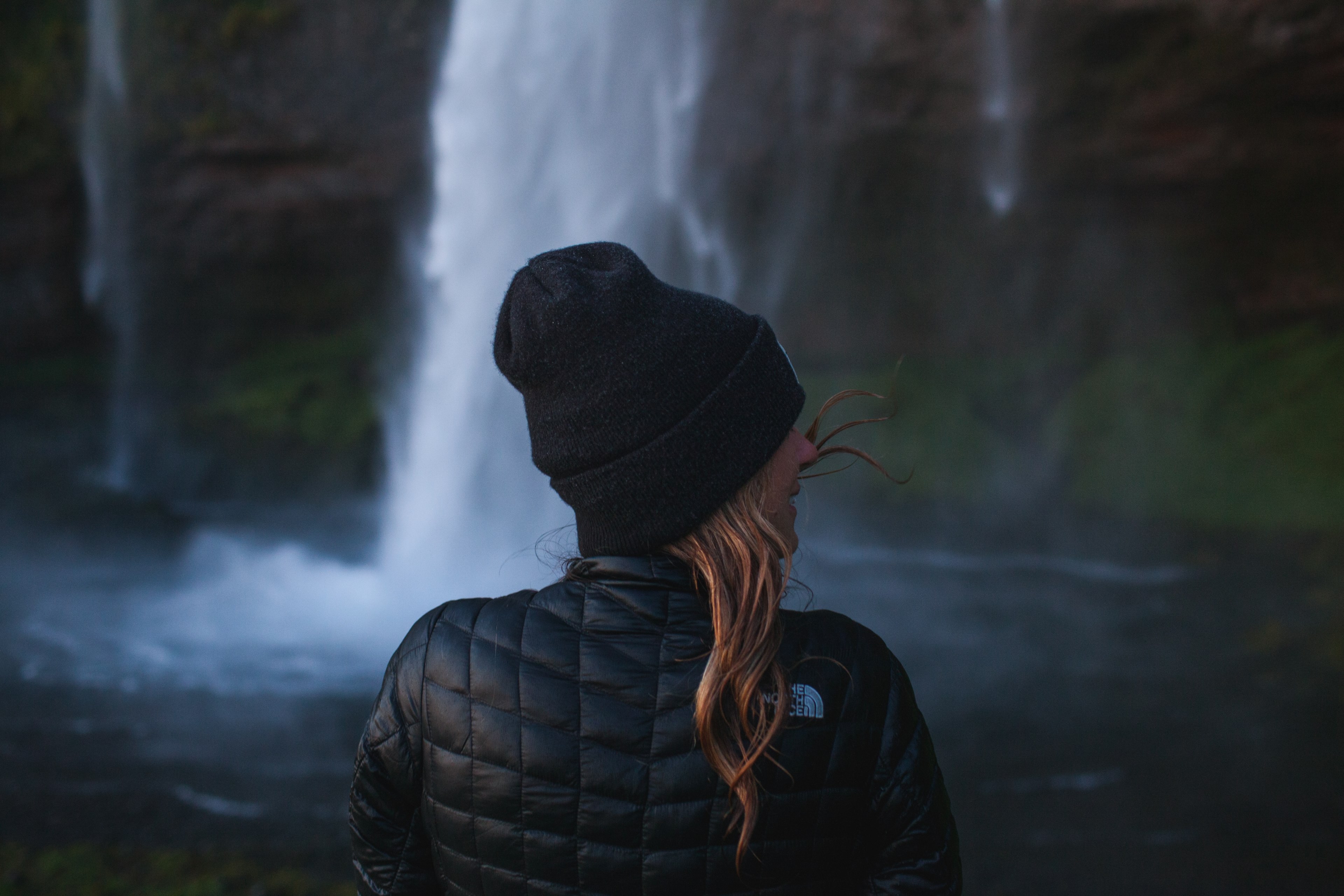a woman in black winter attire is smiling and enjoying the scenery at seljalandsfoss waterfall, _woman seljalandsfoss waterfall 4k, HD Wallpaper