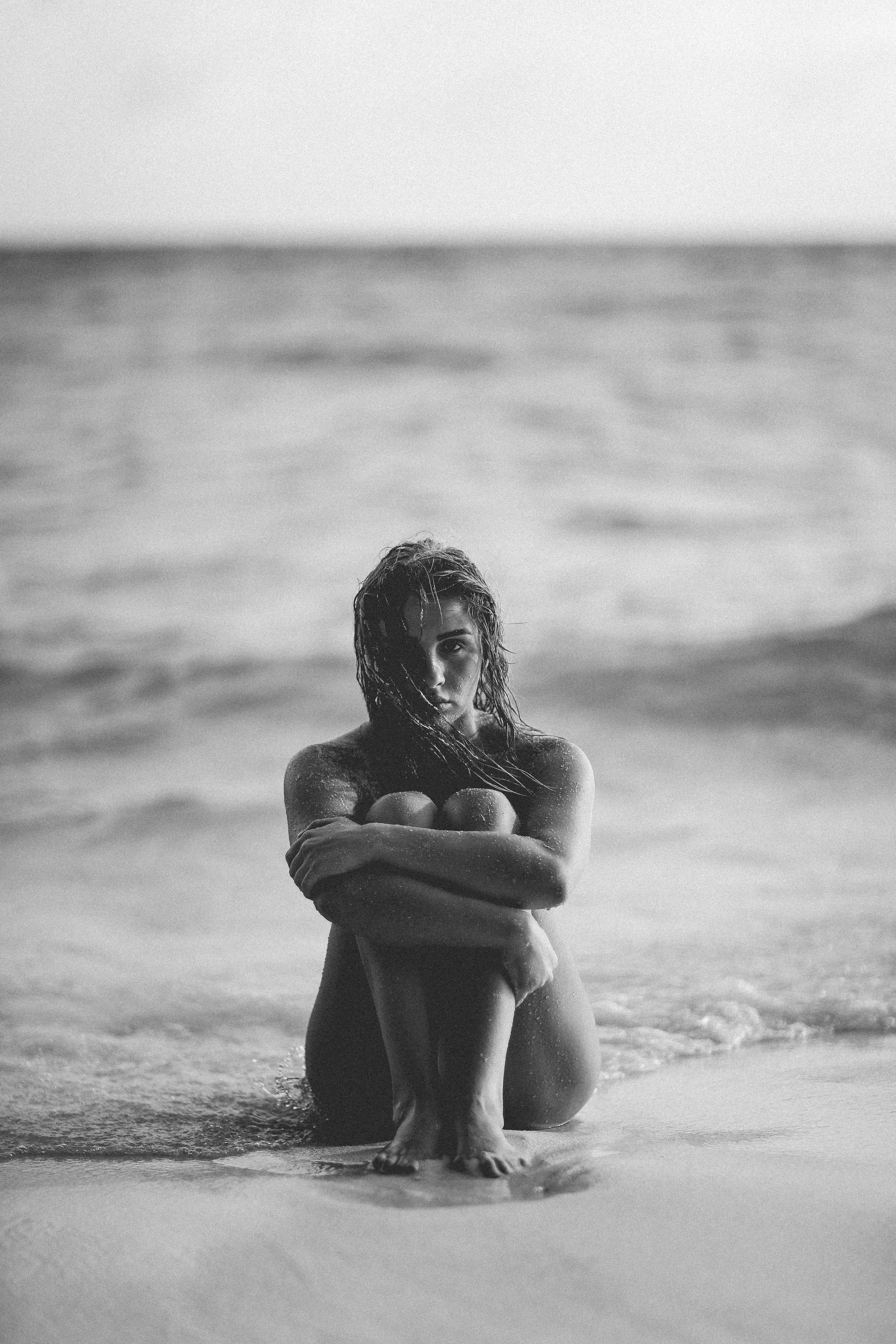 black and white shot of attractive woman sitting with knees up on beach in maldives, maldives 4k, Phone HD Wallpaper