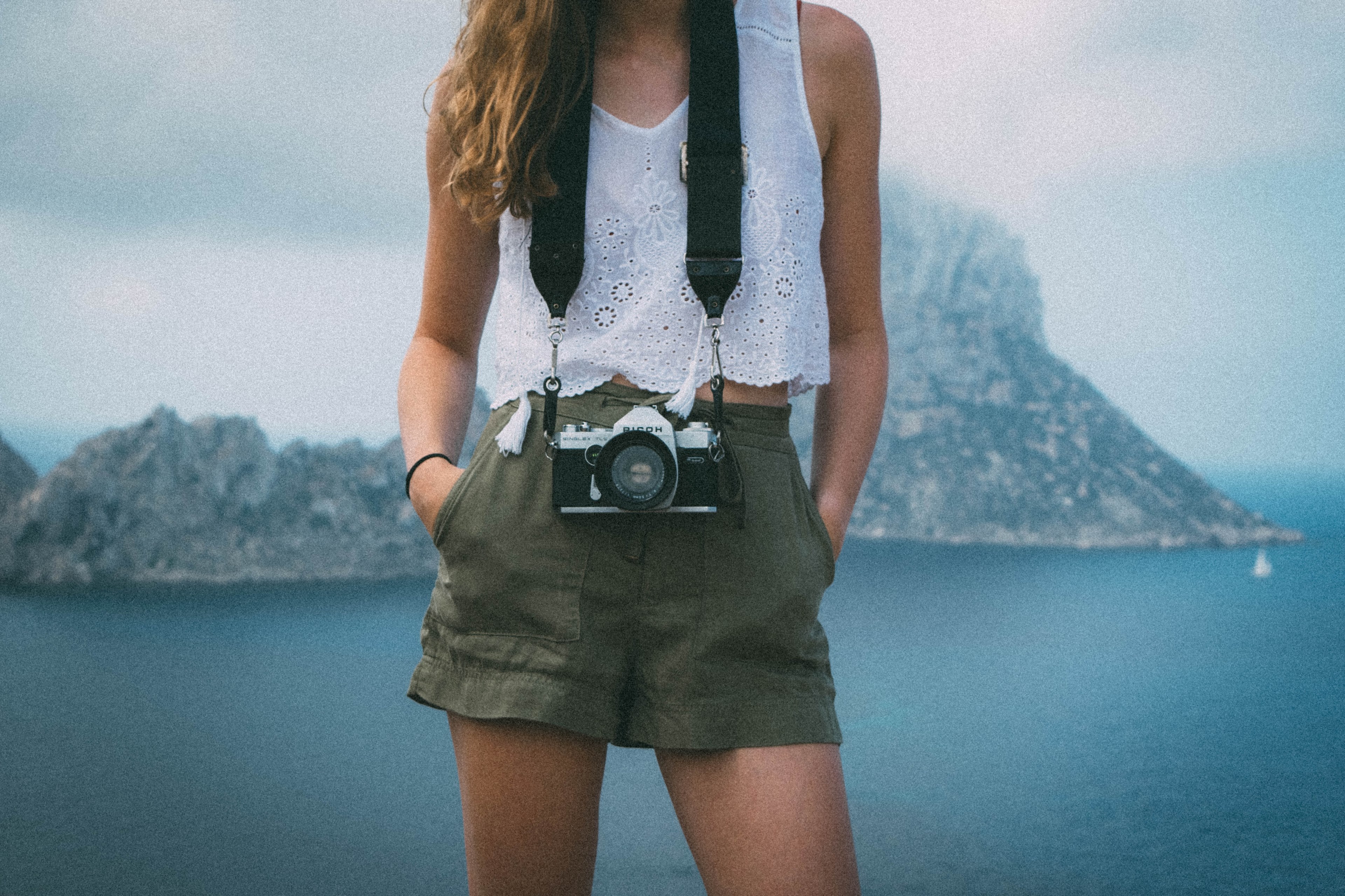 a woman wearing a white eyelet top green shorts and a camera hanging around her neck in es vedra, es vedra camera 4k, HD Wallpaper