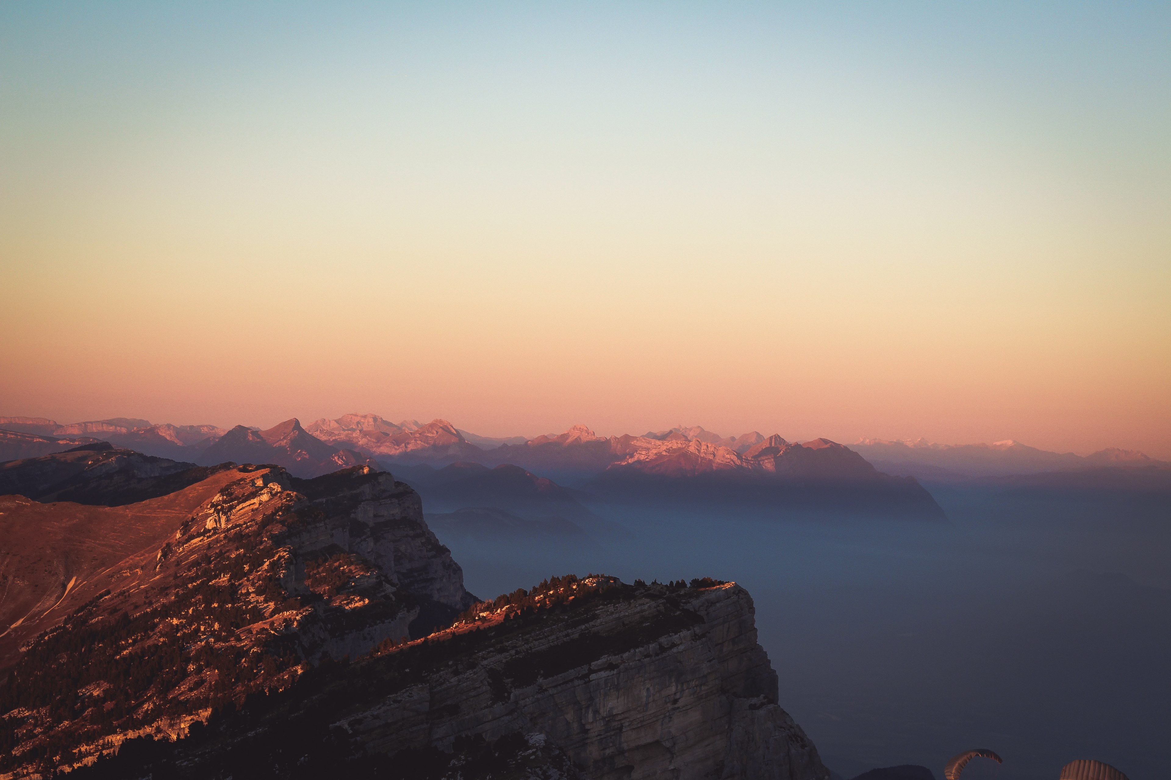 jagged mountain ridges towering over a valley covered by a thick mist, amazing sunset 4k, HD Wallpaper