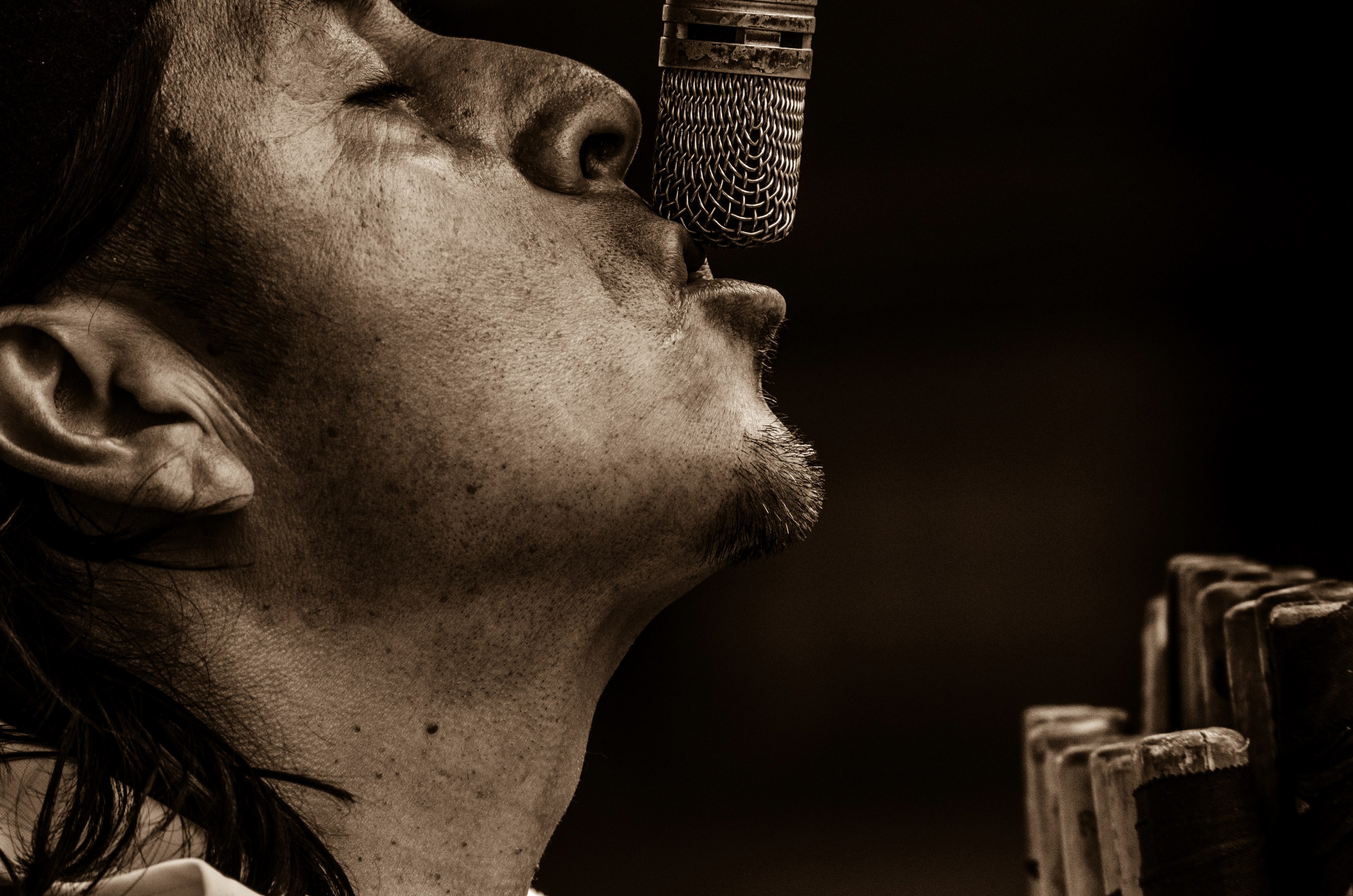 a singer in black and white performs with his mouth against a microphone, performing into a mic 4k, HD Wallpaper