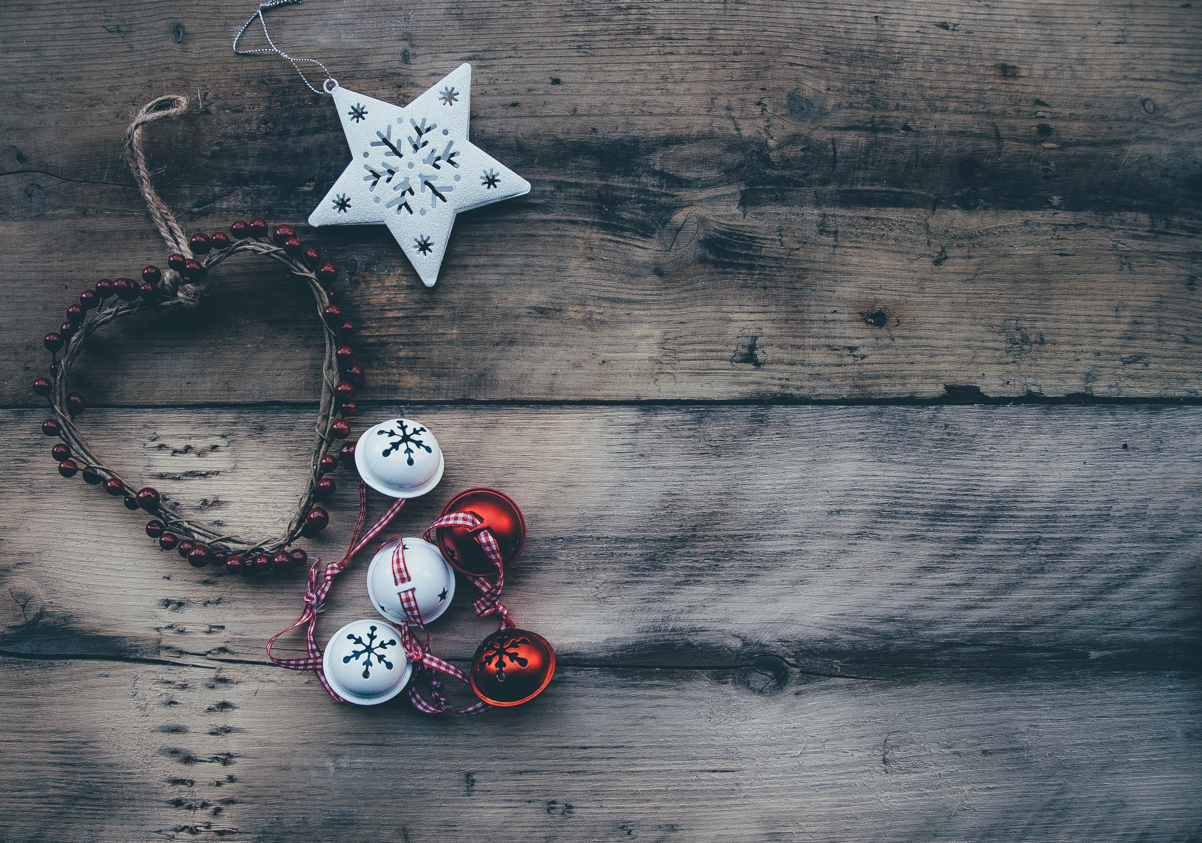 an overhead shot of a white star a string of red beads and white and red bells on a wooden surface, christmas decorations in flatlay 4k, HD Wallpaper