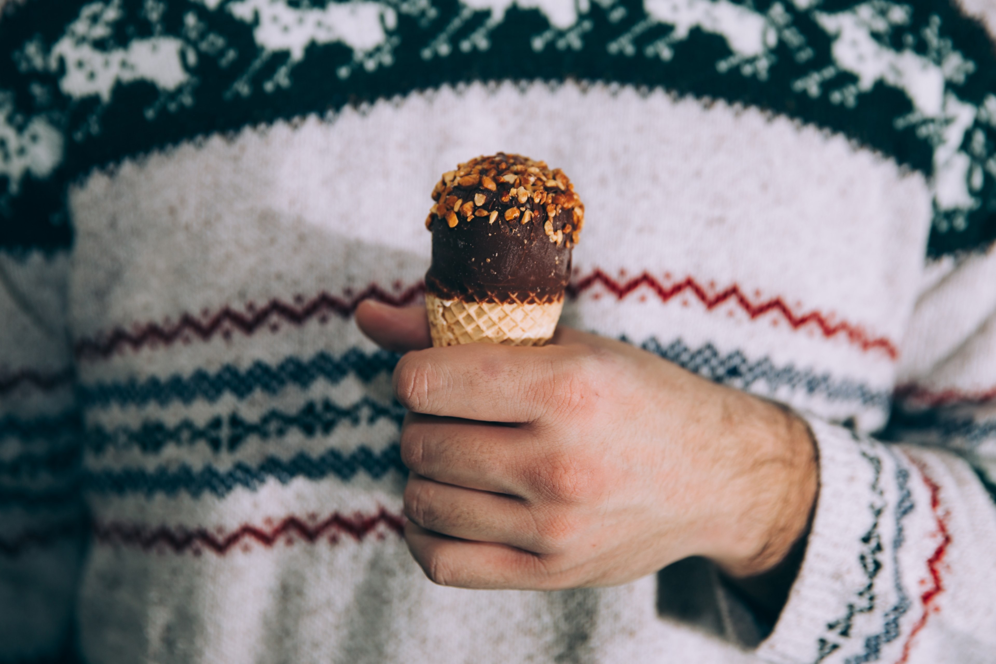 person wearing a cozy sweater and eating a drumstick ice cream cone, cold treats 4k, HD Wallpaper