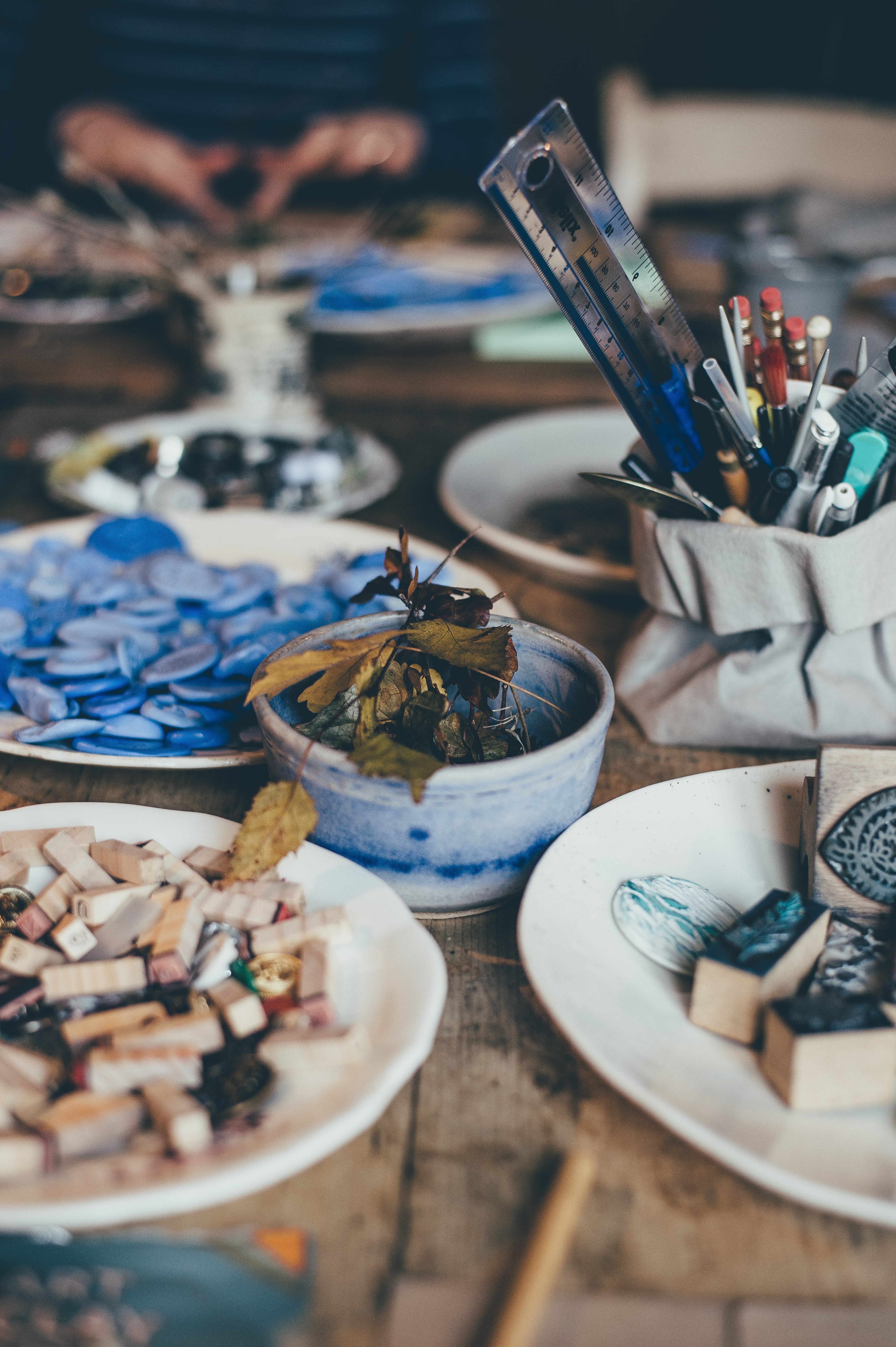 messy art supplies in bowls and plates on wooden table with ruler in pot, making winter 4k, Phone HD Wallpaper