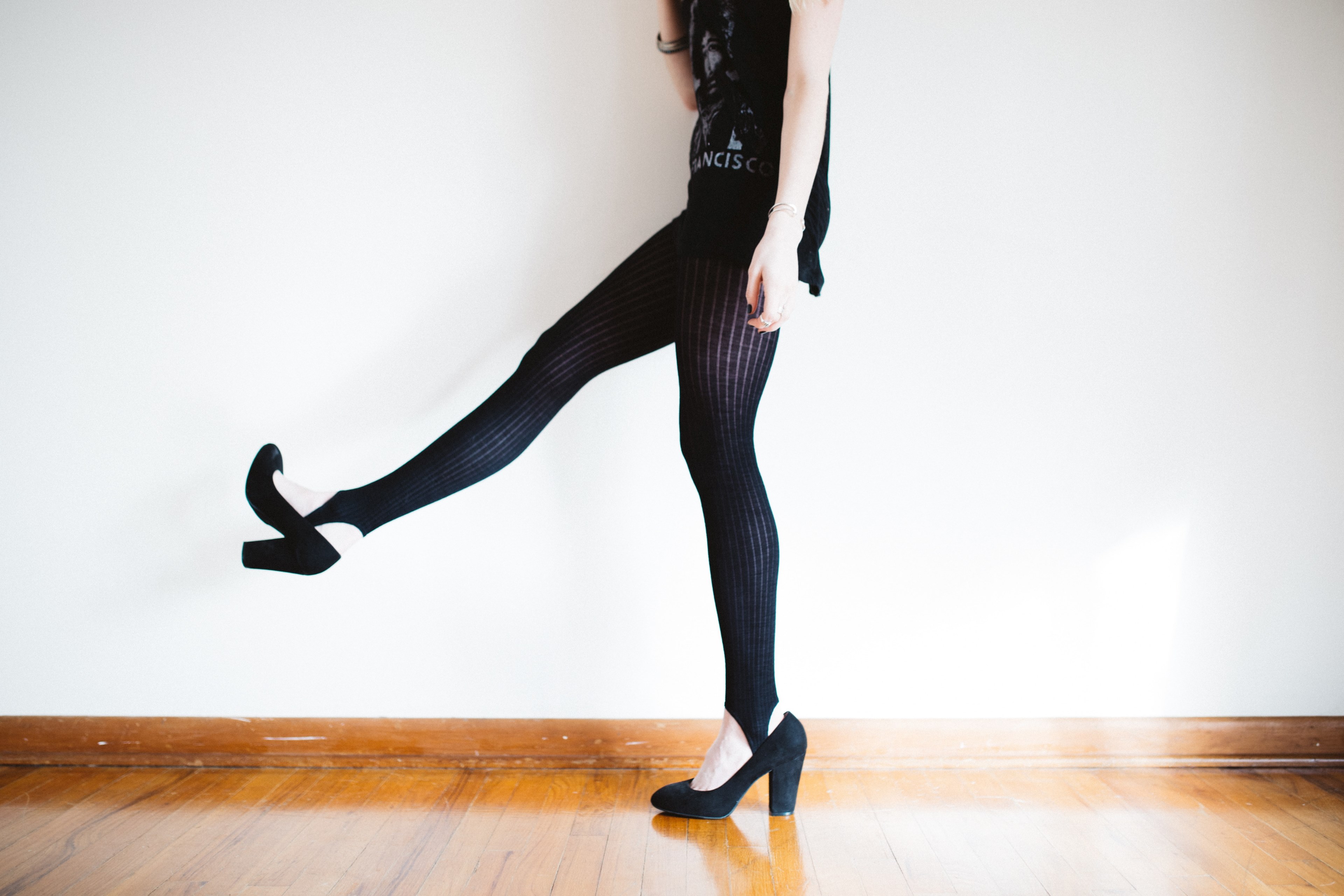 a woman wearing all black tights and shoes kicking her leg up, woman in black 4k, HD Wallpaper