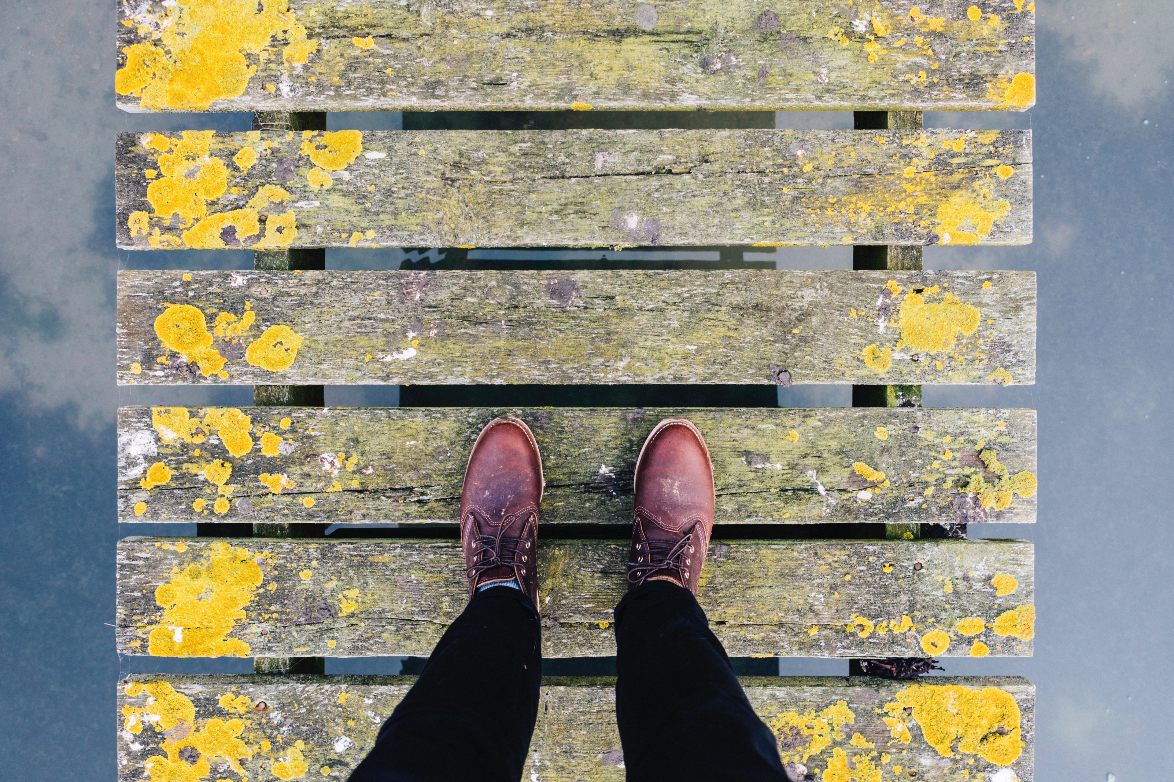 a person wearing burgundy color footwear walking on a fence style bridge, narrow walking by harbor 4k, HD Wallpaper