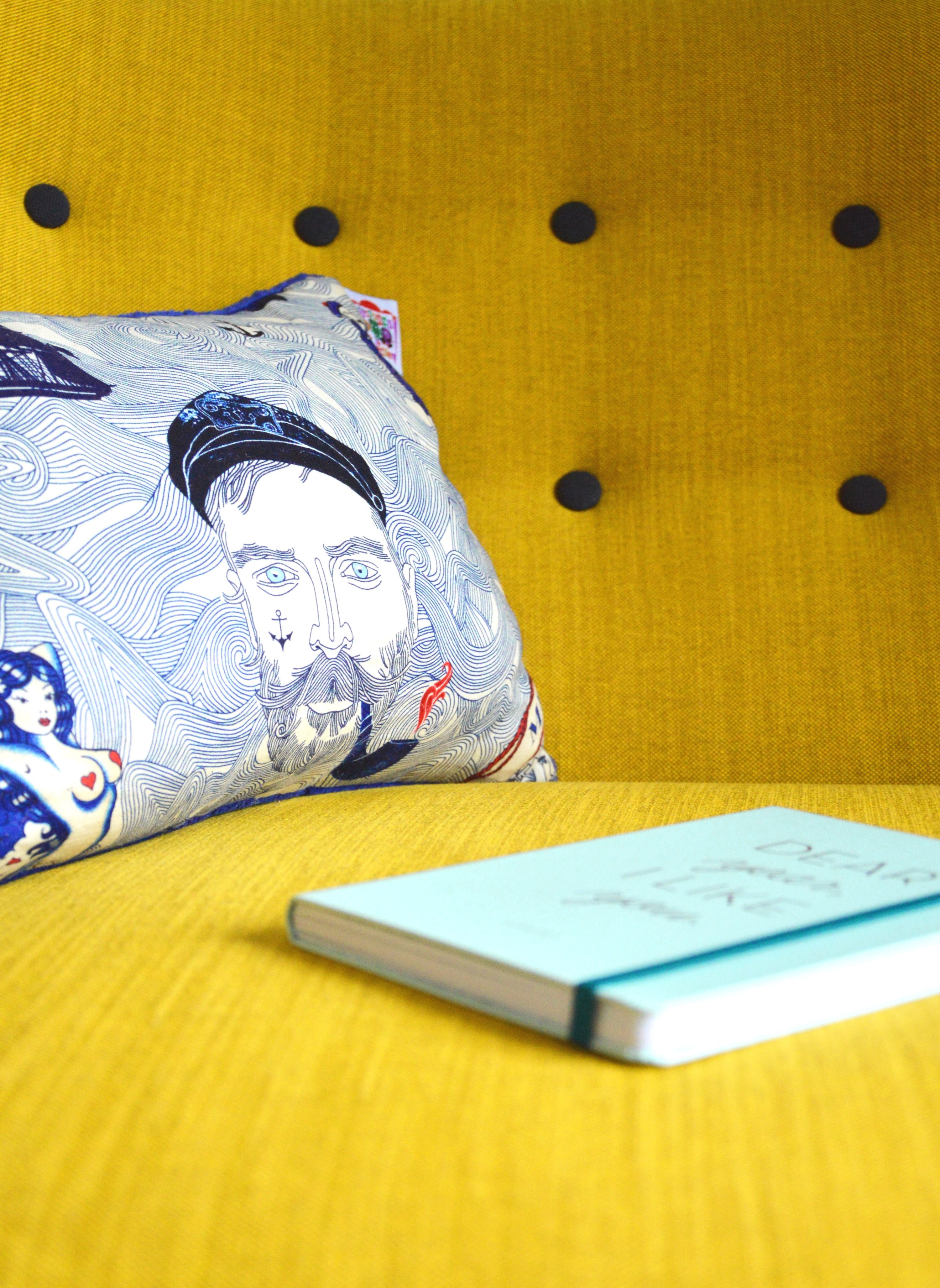 hardcover book sitting on the yellow couch in front of nautically themed pillow, hardcover book on a yellow couch 4k, Phone HD Wallpaper