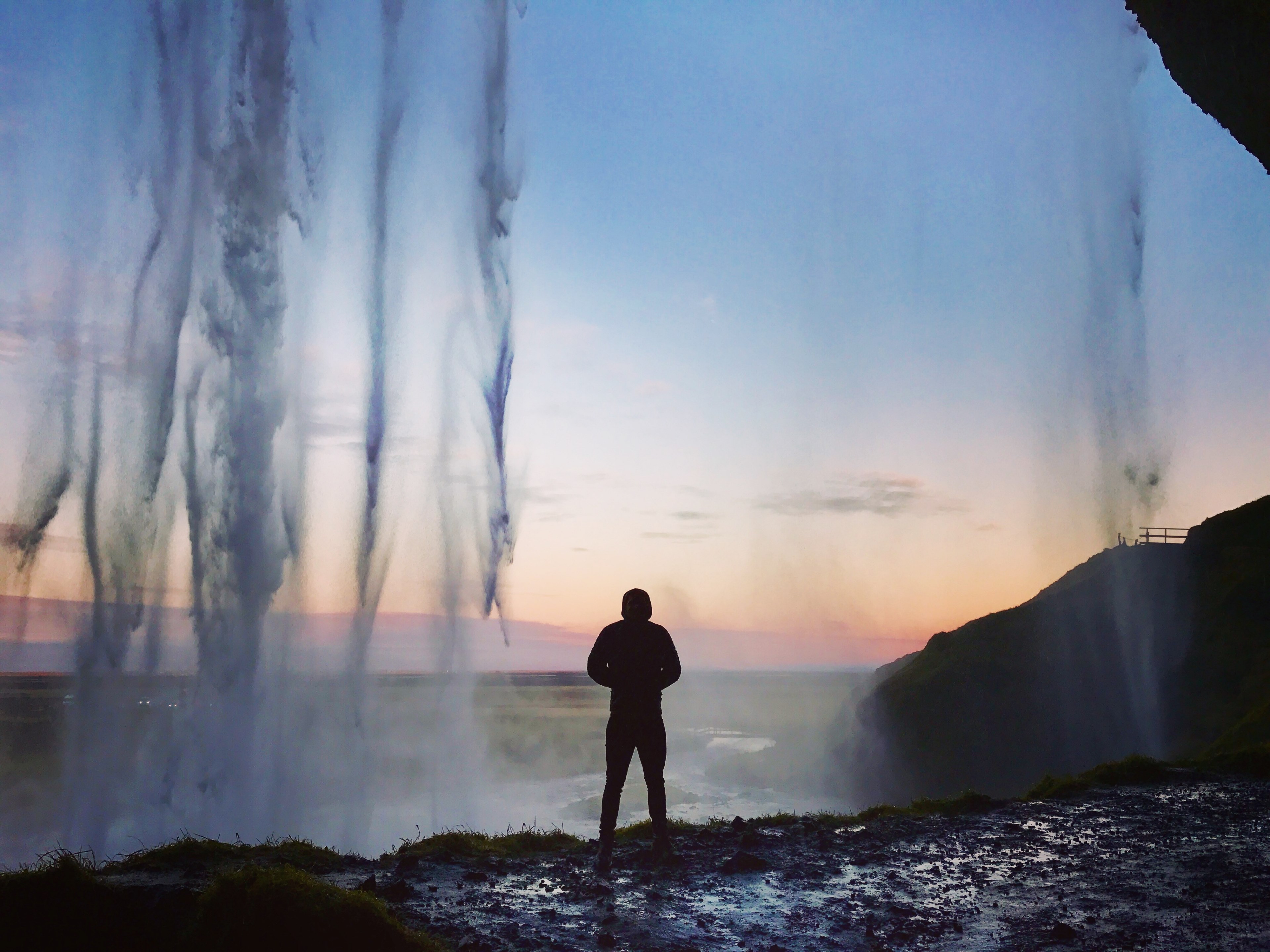 a person staring at the sunset from behind a large waterfall in the southern region of iceland, behind iceland waterfall 4k, HD Wallpaper