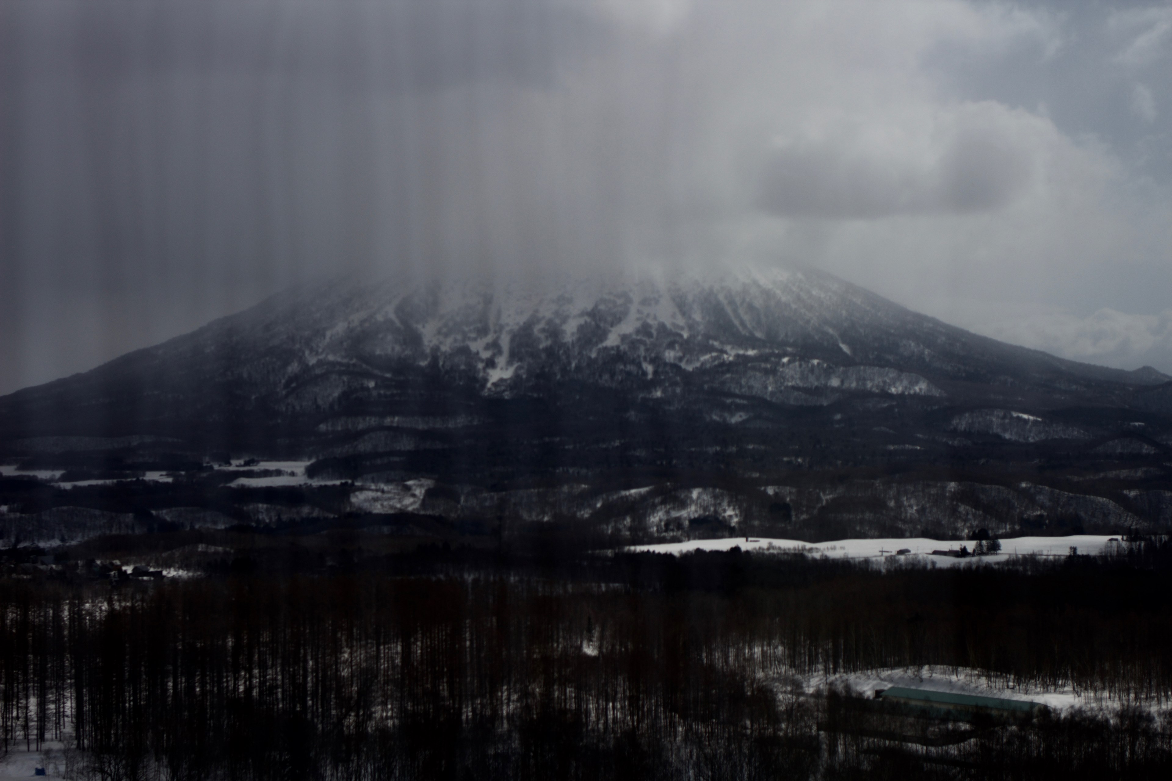 a massive mountain towering over wintry landscape as clouds gather around its peak, massive mountain in clouds 4k, HD Wallpaper