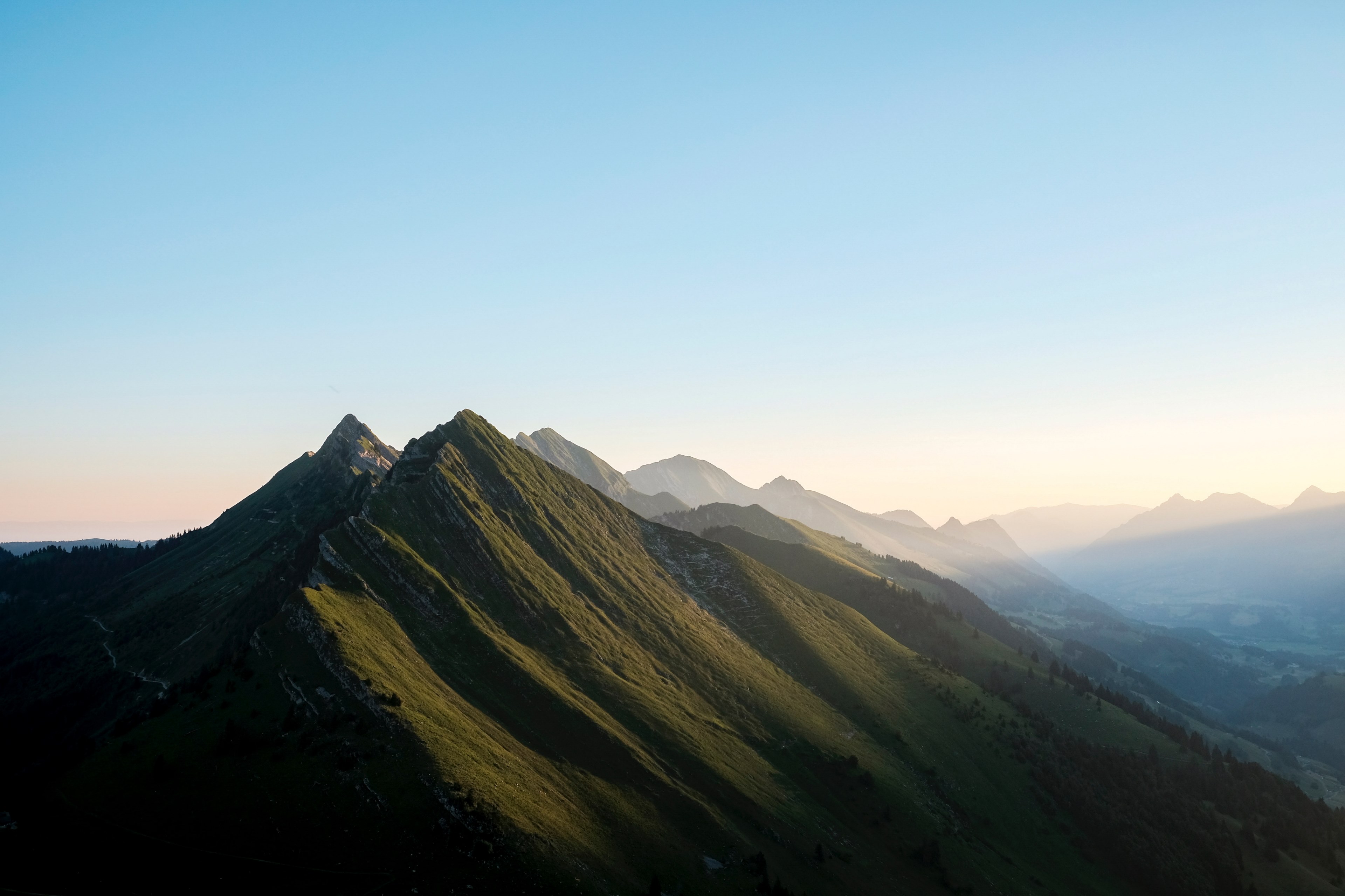 a sloping mountain range with pointy peaks under a blue sky with soft sunlight, mountain sunrise ridge and slope 4k, HD Wallpaper