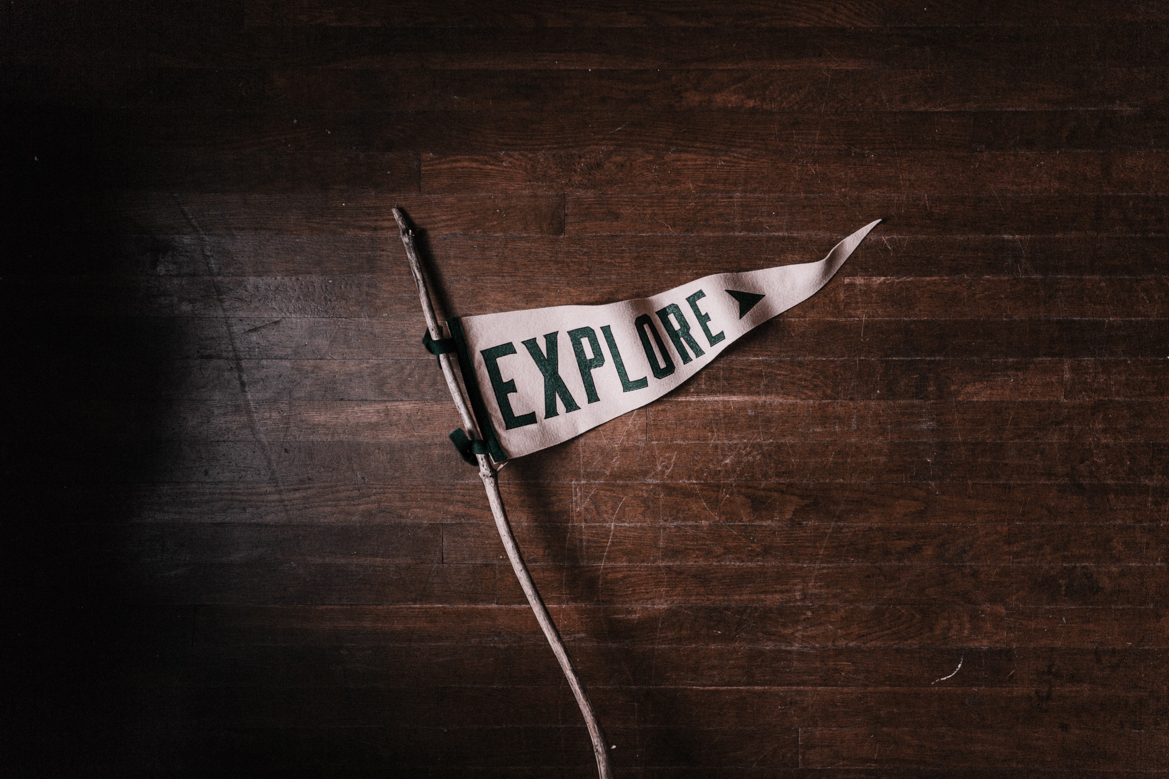 a white pennant that says explore on a dark wooden floor, explore more 4k, HD Wallpaper