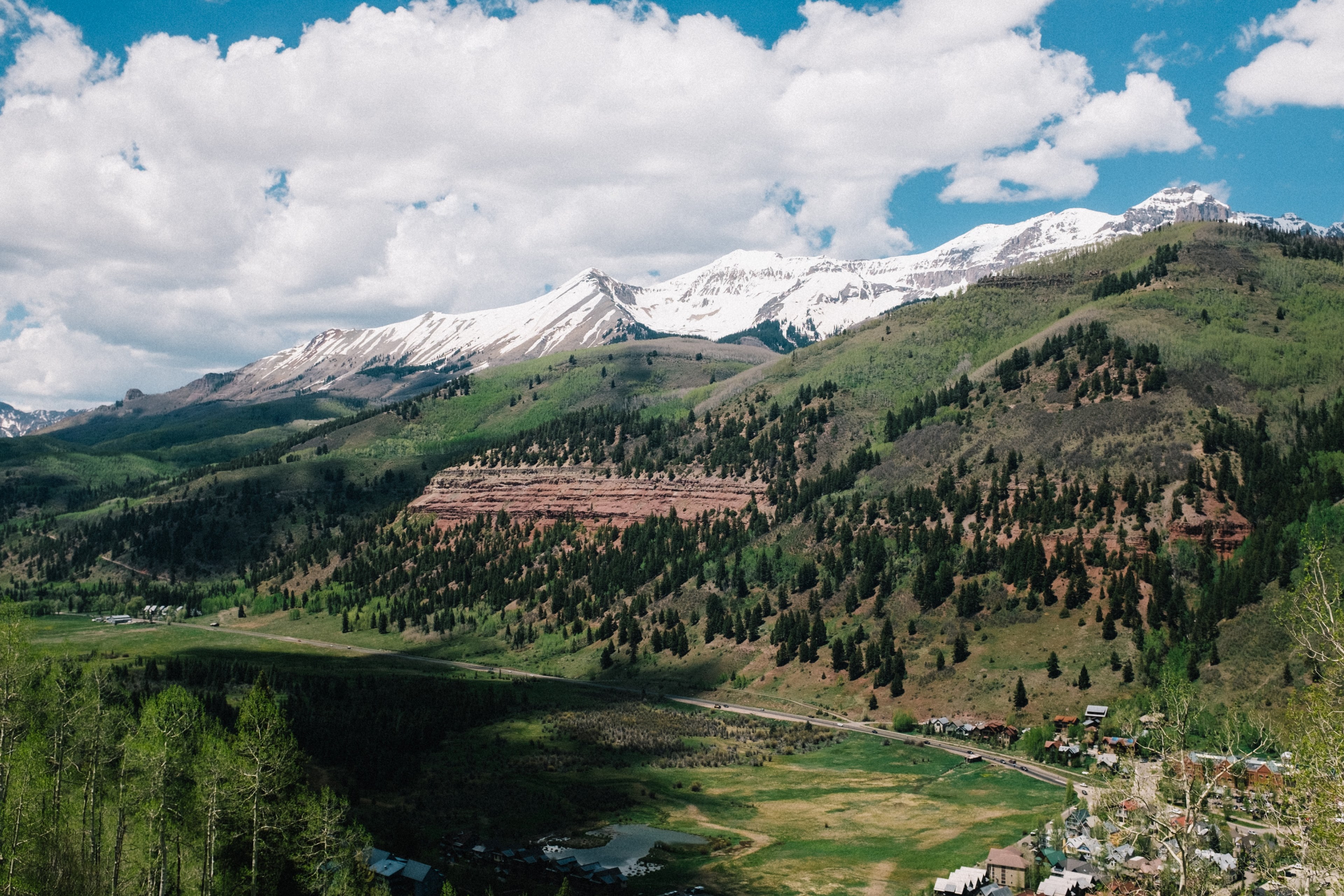 a valley in telluride surrounded by a hill covered with trees and a mountain range behind, grassy mountainside in telluride 4k, HD Wallpaper