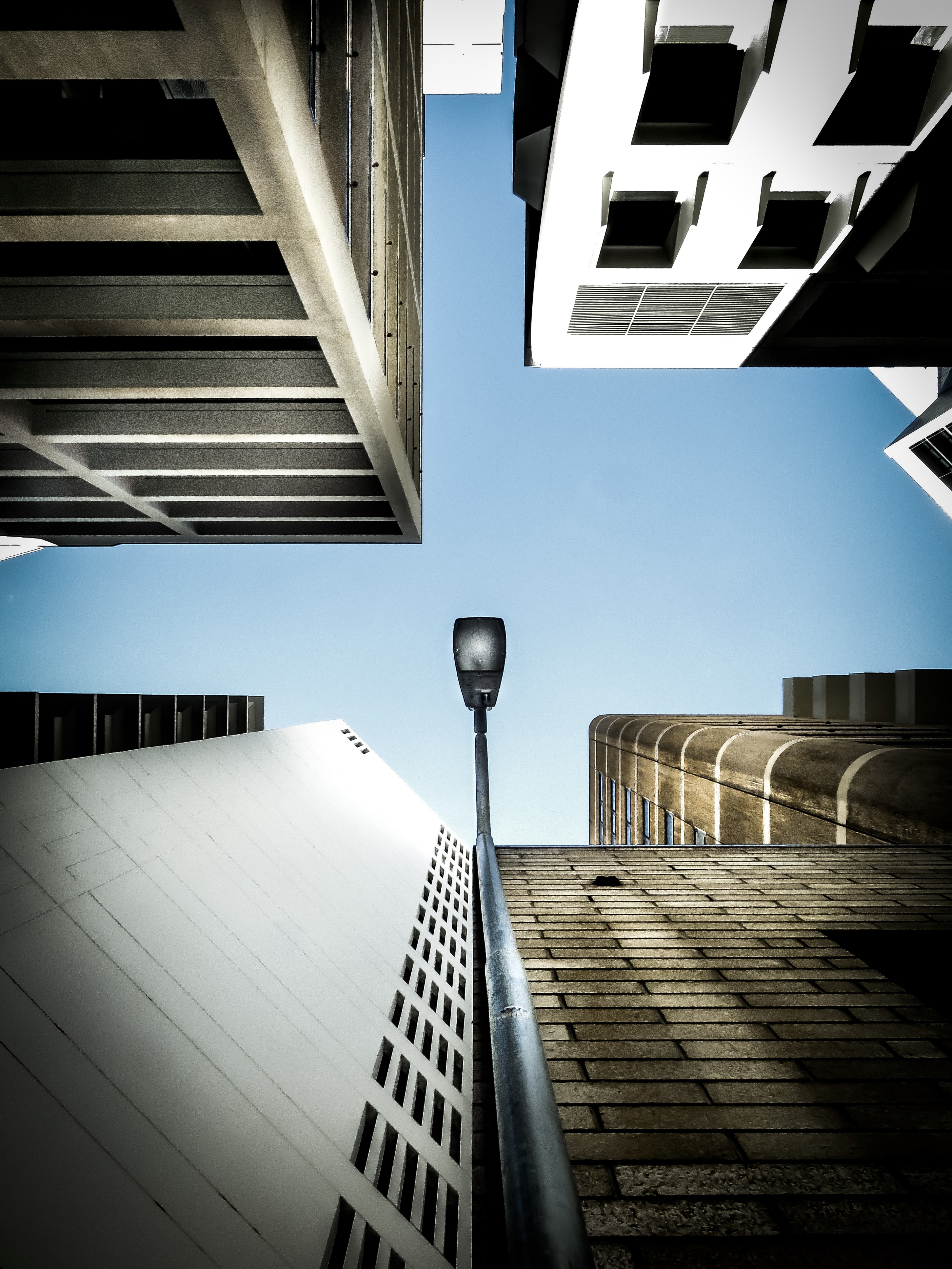 a low angle shot of a lamppost adjacent to a building facade, lamppost on a facade 4k, Phone HD Wallpaper