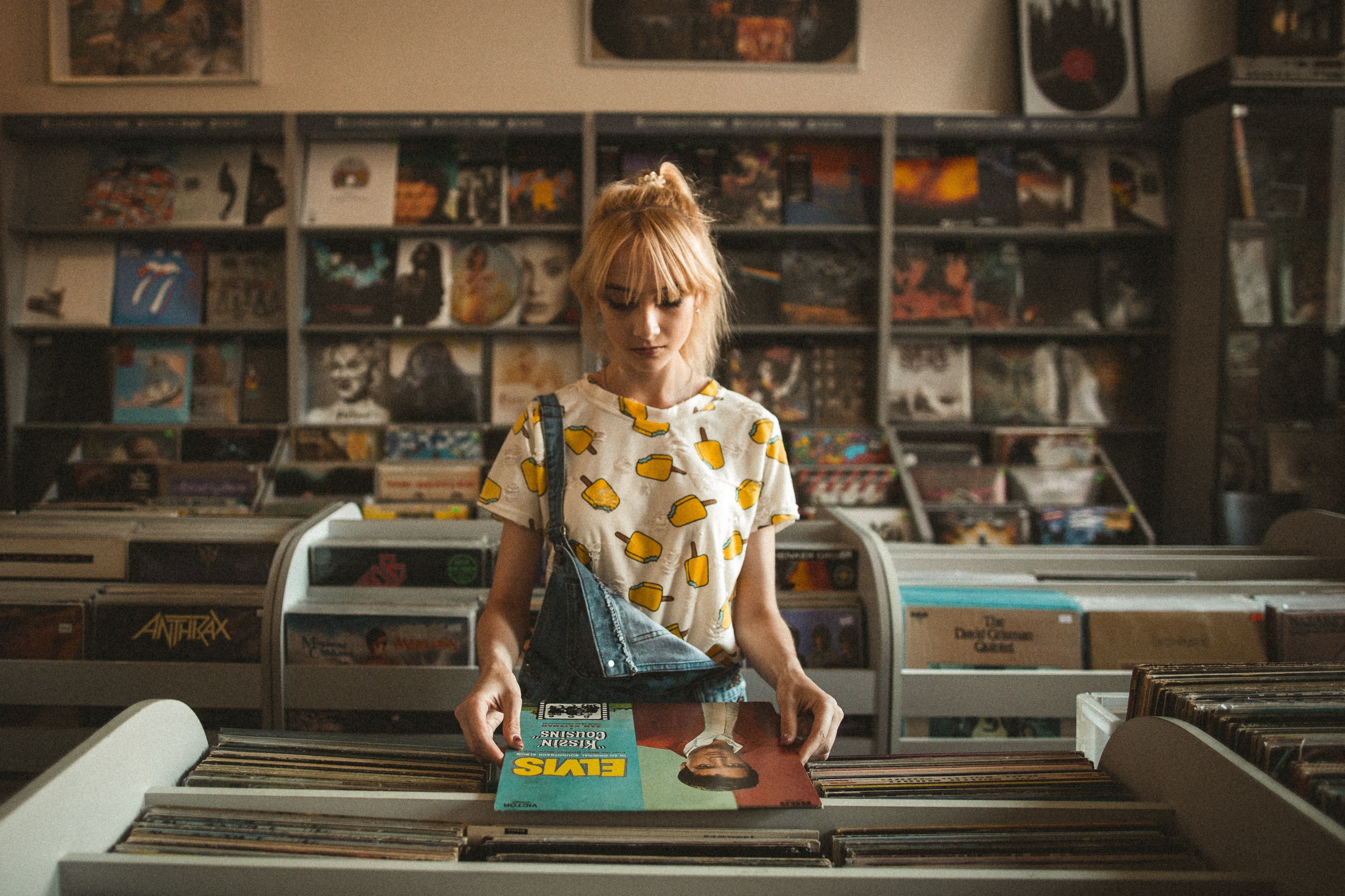 a young blonde woman looking at elvis presleys vinyl record in a record store, elvis in a record store 4k, HD Wallpaper