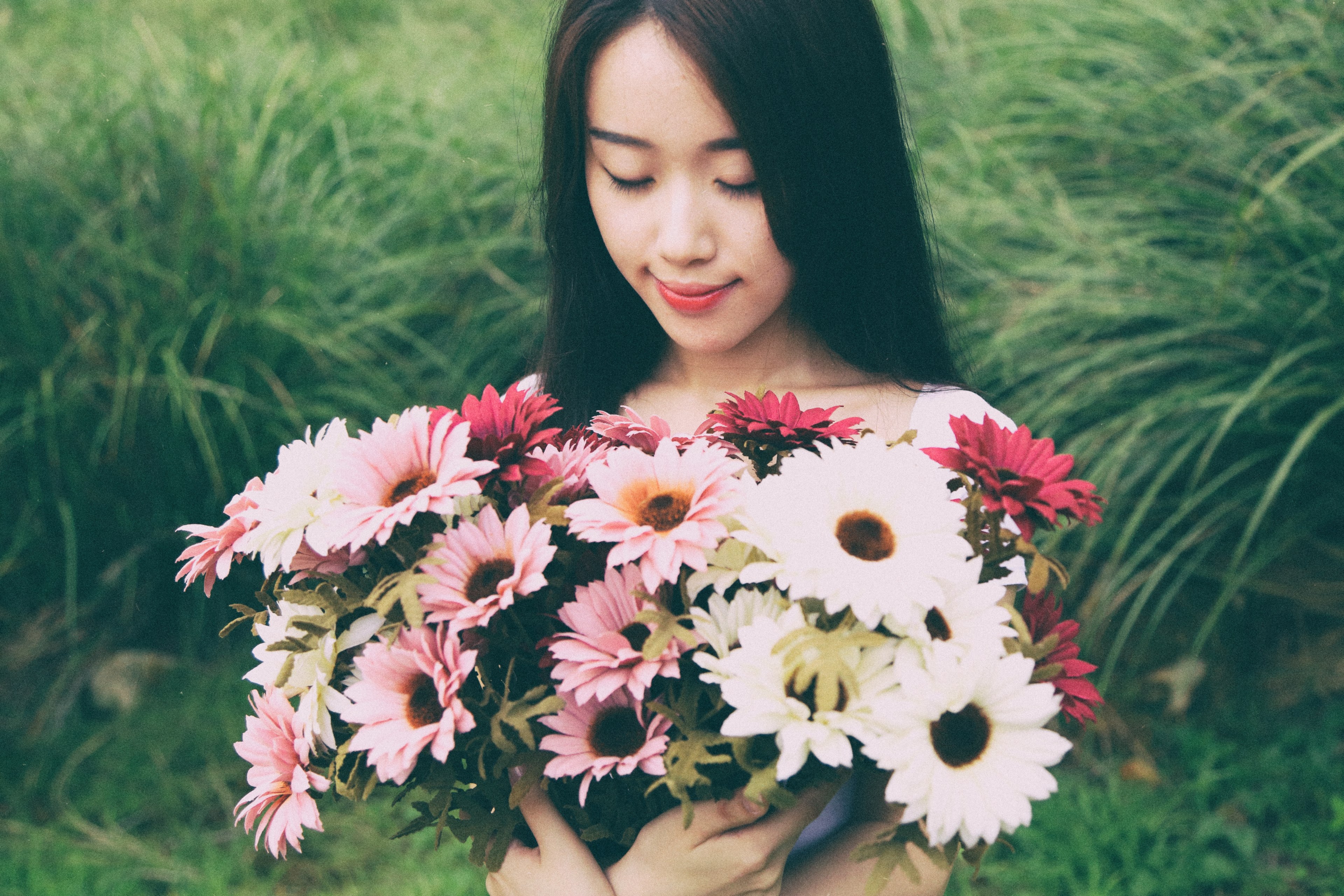 a dark haired woman holding a large bouquet of pink and white flowers in a meadow, woman with a bouquet in the meadow 4k, HD Wallpaper