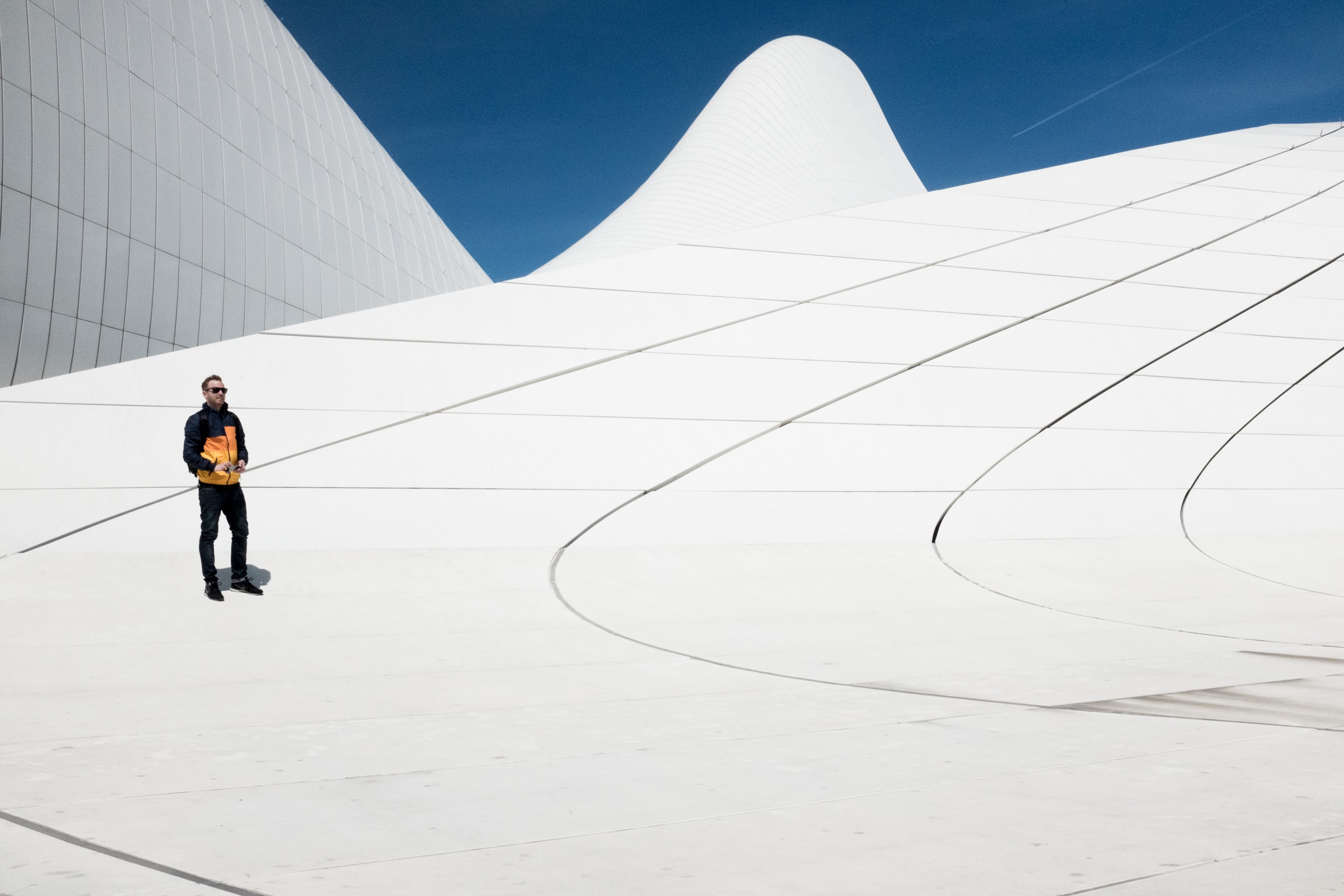 a man wearing a yellow and black jacket standing on an installation at heydar aliyev centre, heydar aliyev center baku 4k, HD Wallpaper