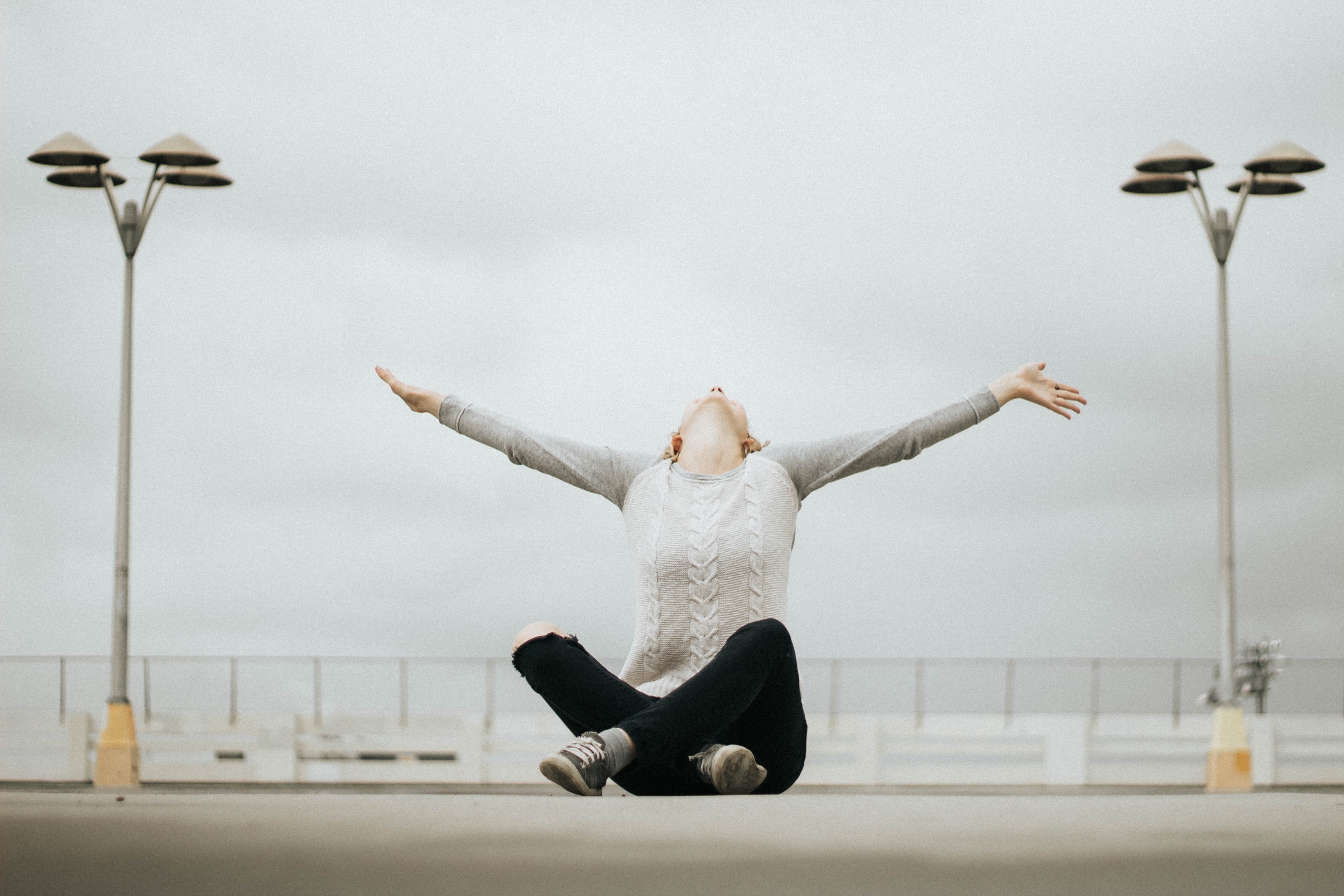 a woman in ripped jeans sitting cross legged and outstretching her arms while leaning back, happiness 4k, HD Wallpaper