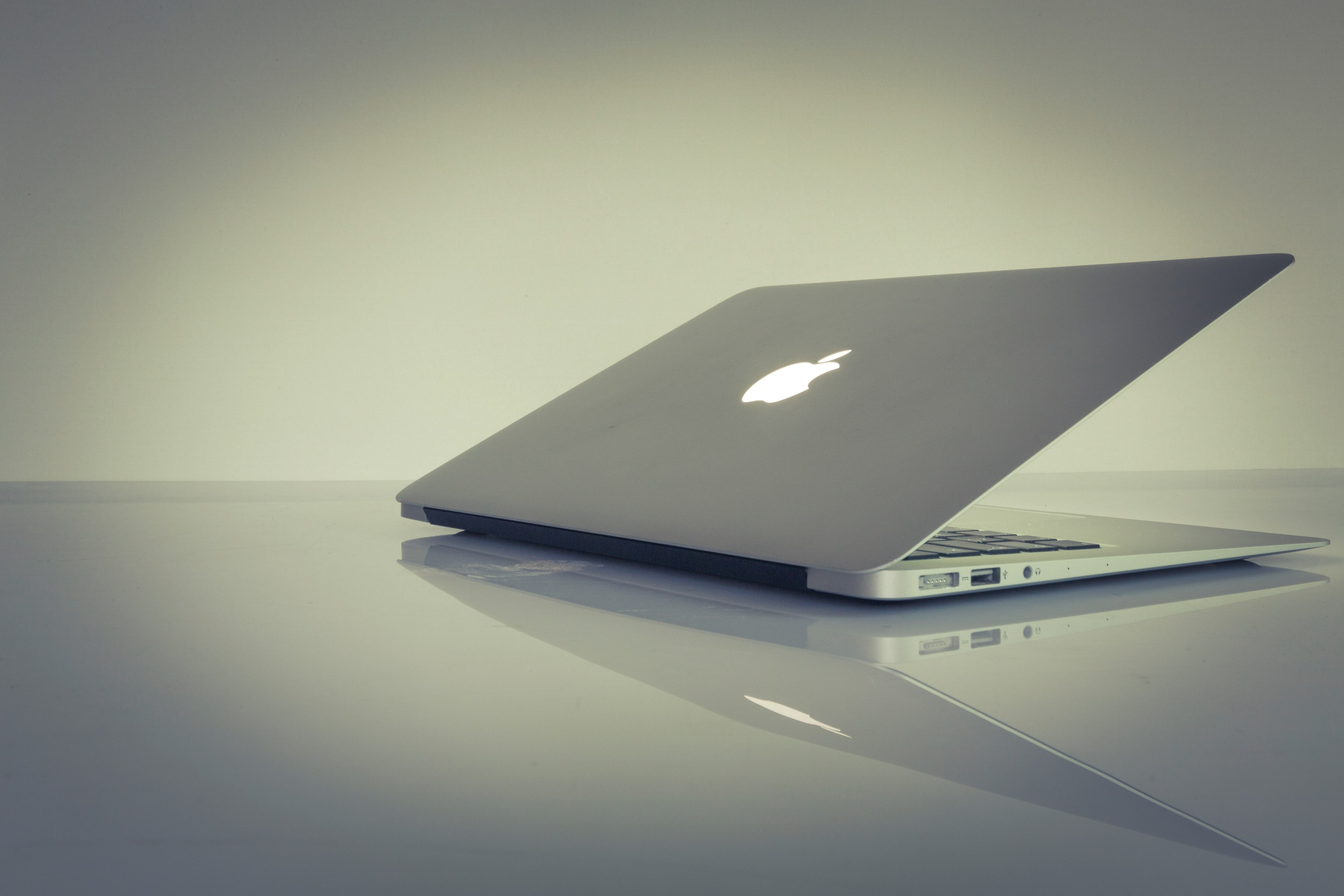 a half closed macbook on a reflective surface, half closed laptop 4k, HD Wallpaper