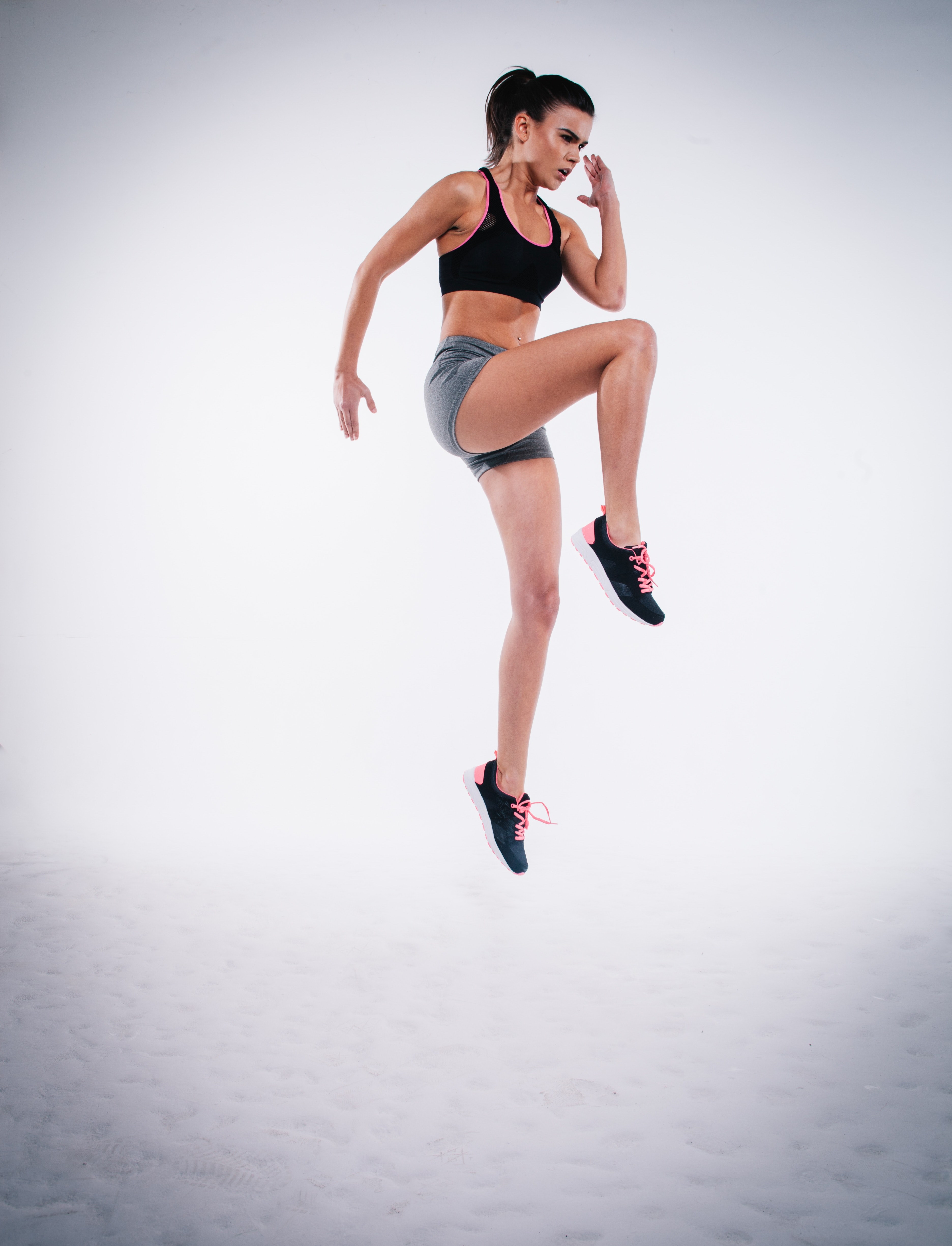 a determined woman in a sports bra jump lunging into the sky in london, woman jump lunging 4k, Phone HD Wallpaper