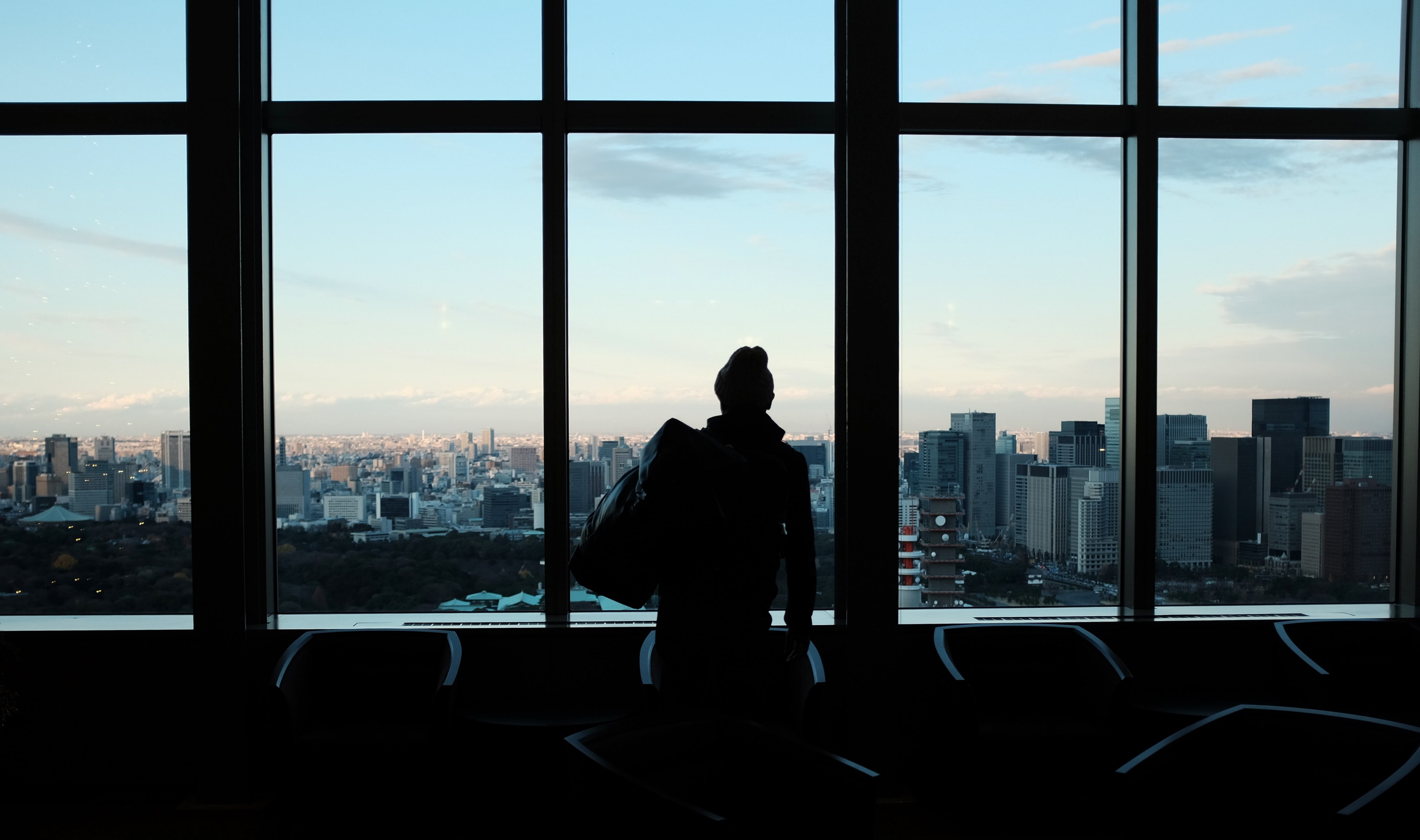 a silhouette of a person staring out large office building windows at the citys architecture, staring out building windows 4k, HD Wallpaper