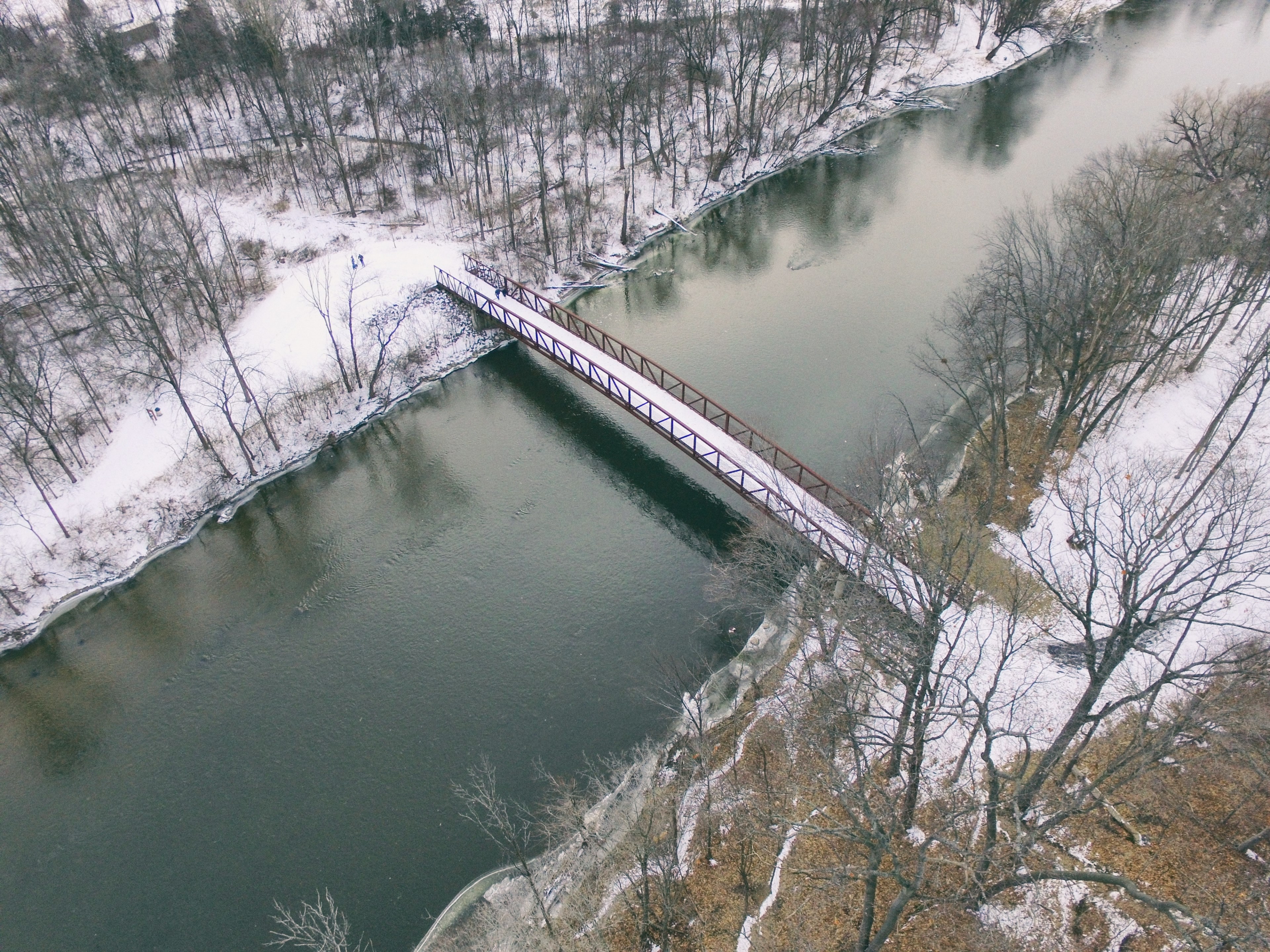 aerial view of a bridge crossing a river surrounded by a winter landscape, over the river 4k, HD Wallpaper
