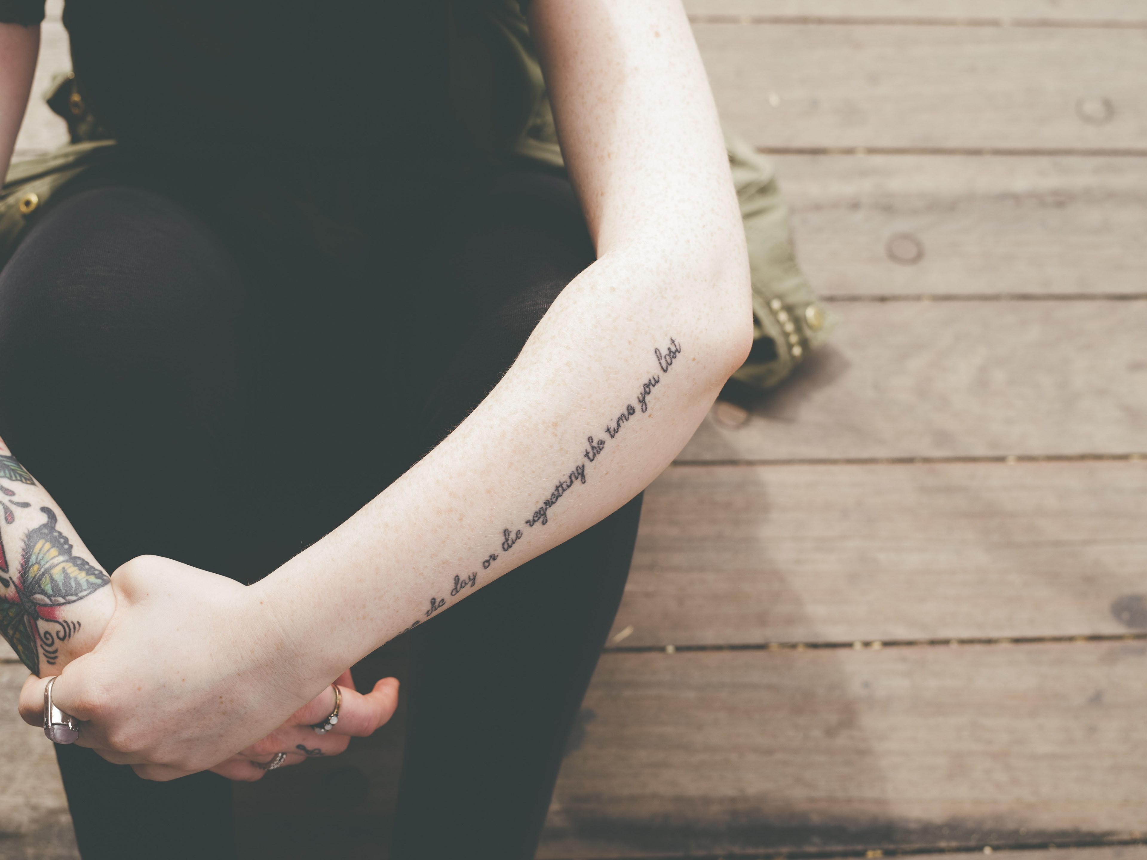 woman with butterfly and quote tattoos sitting on the wooden dock of liberty island, woman sitting on wooden dock 4k, HD Wallpaper