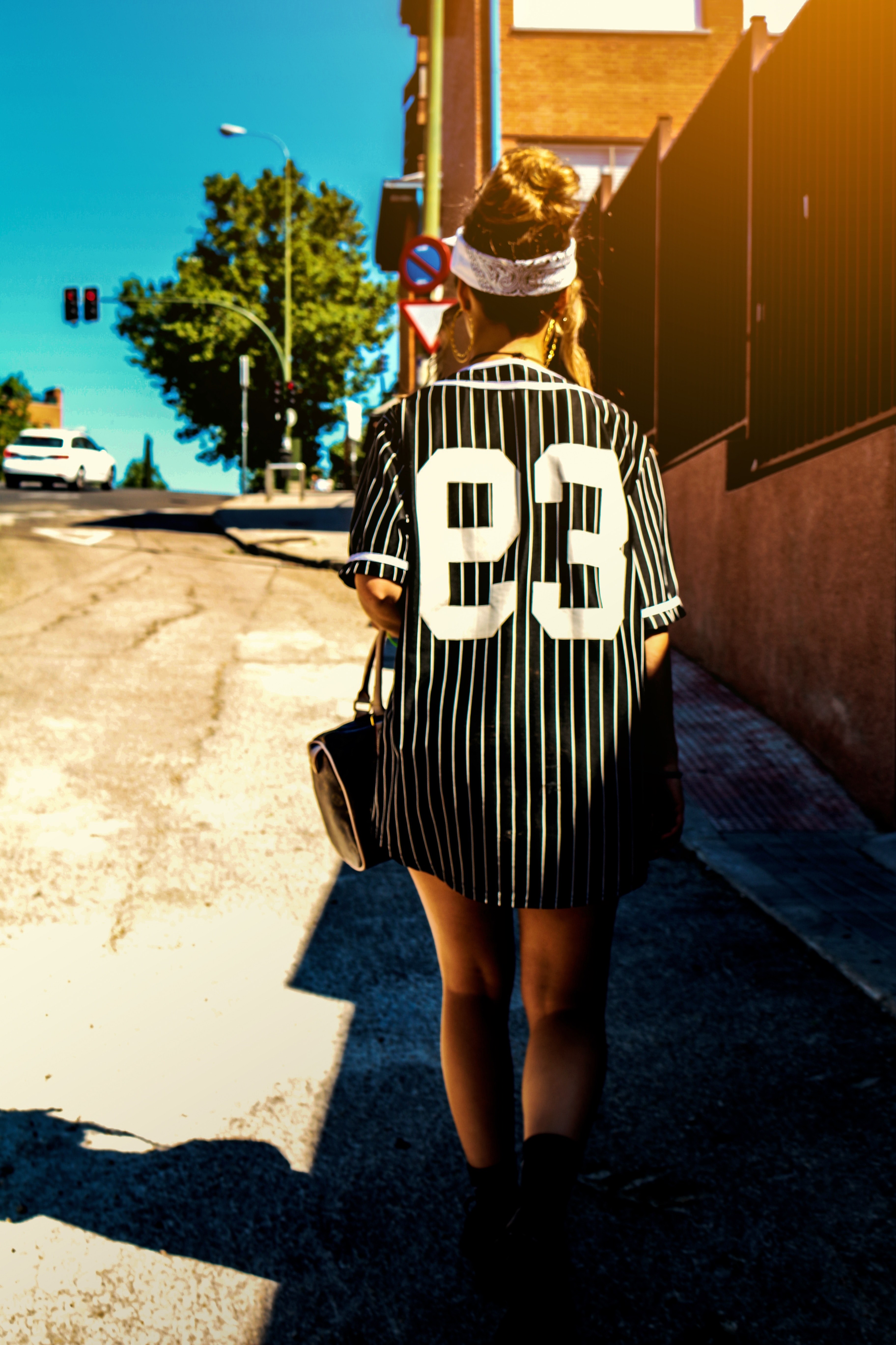 a woman in a striped black shirt walking along a road in madrid, 93 4k, Phone HD Wallpaper