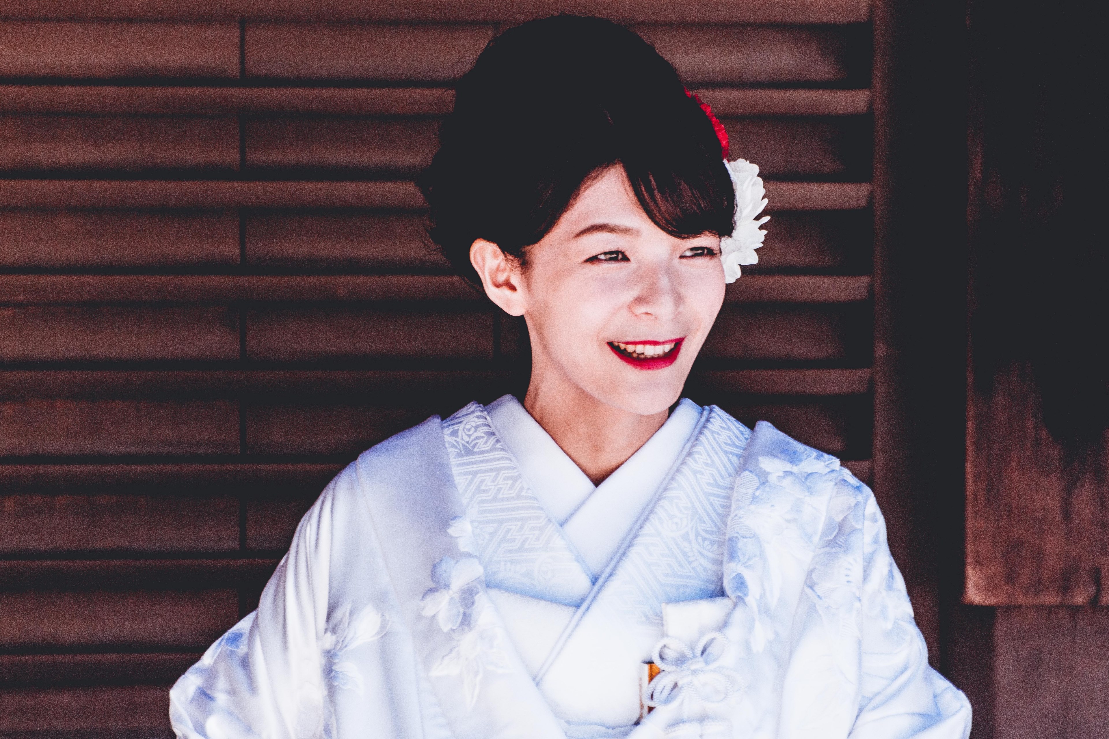 a smiling woman in a white kimono with white and red flowers in her hair, kimono clad woman with flowers in hair 4k, HD Wallpaper