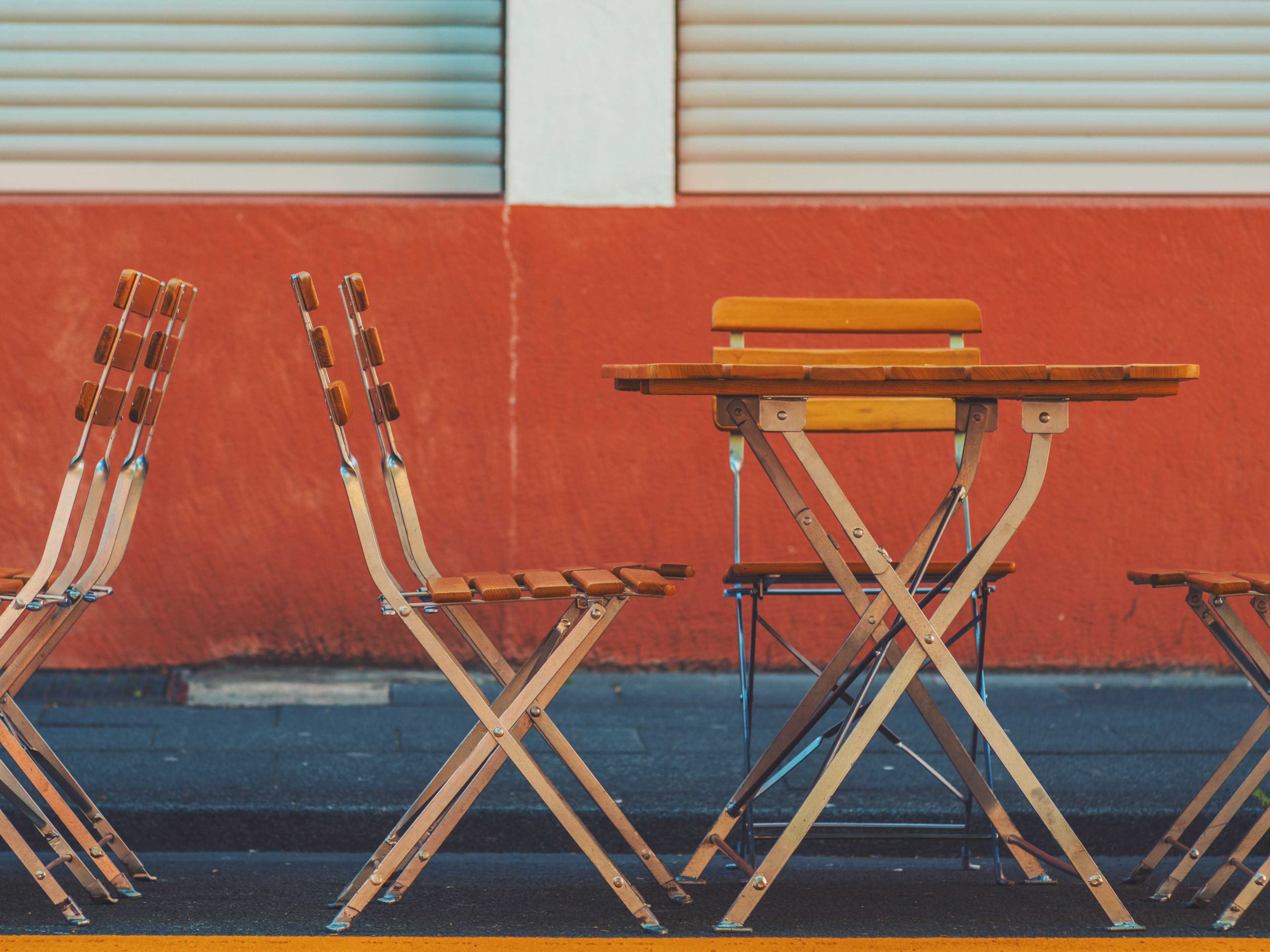 empty wooden table and chairs against a dark red wall in cologne, table and chairs in cologne 4k, HD Wallpaper