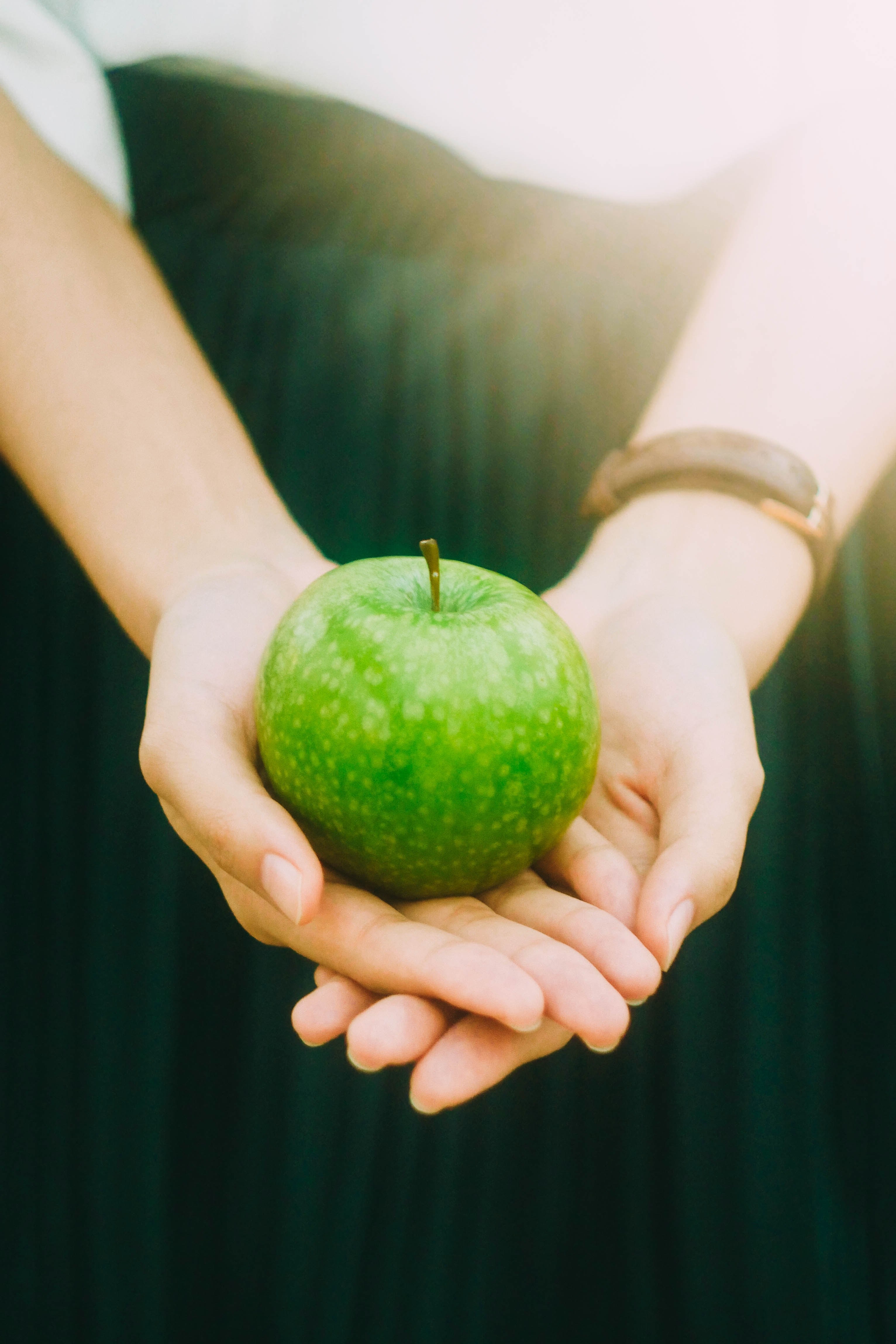 woman wearing watch and green dress holding green apple with sunlight streaming in, the green apple story 4k, Phone HD Wallpaper