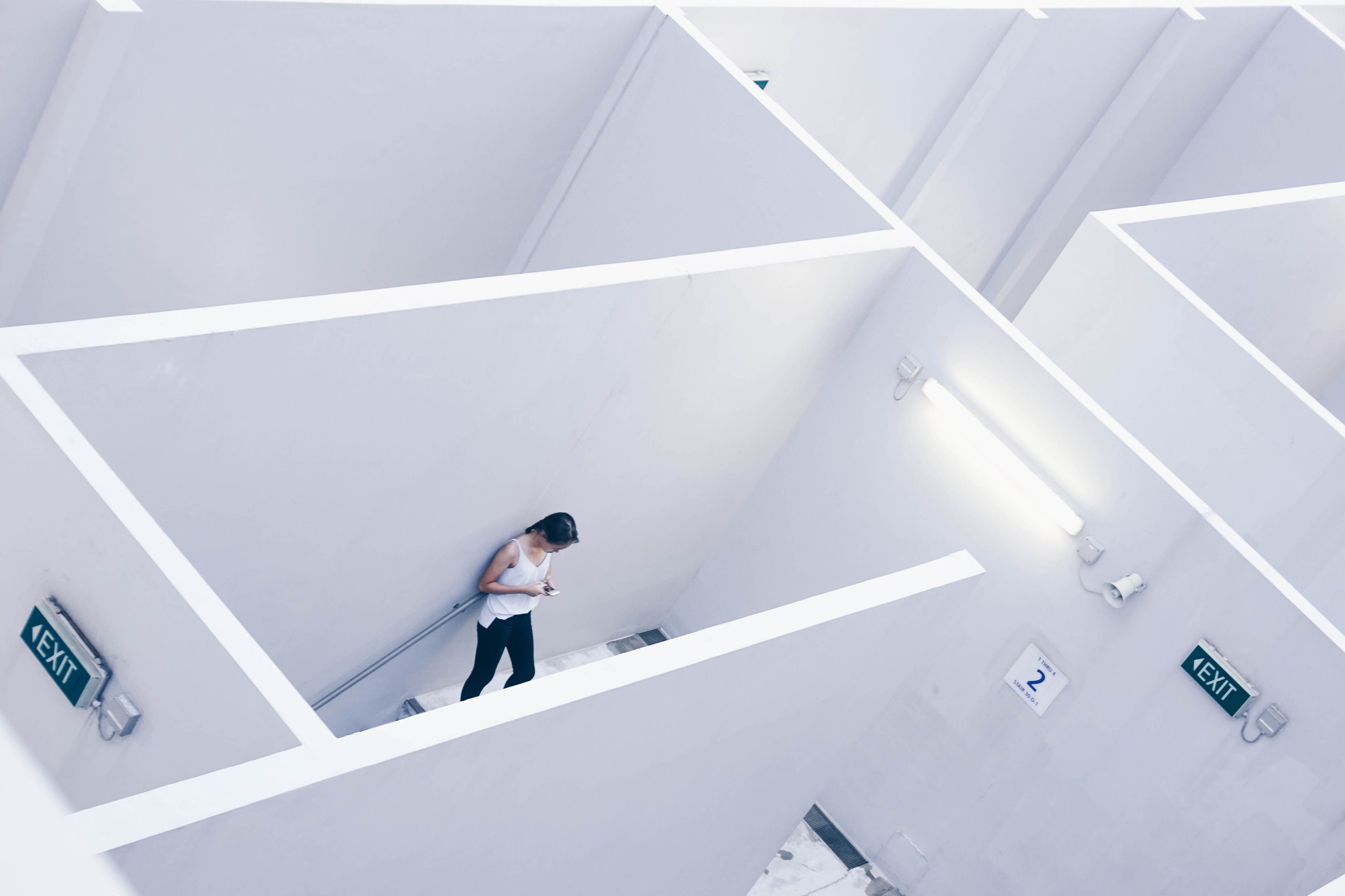 an high shot of a woman using a smartphone in the white maze of an office building, woman in a white maze 4k, HD Wallpaper